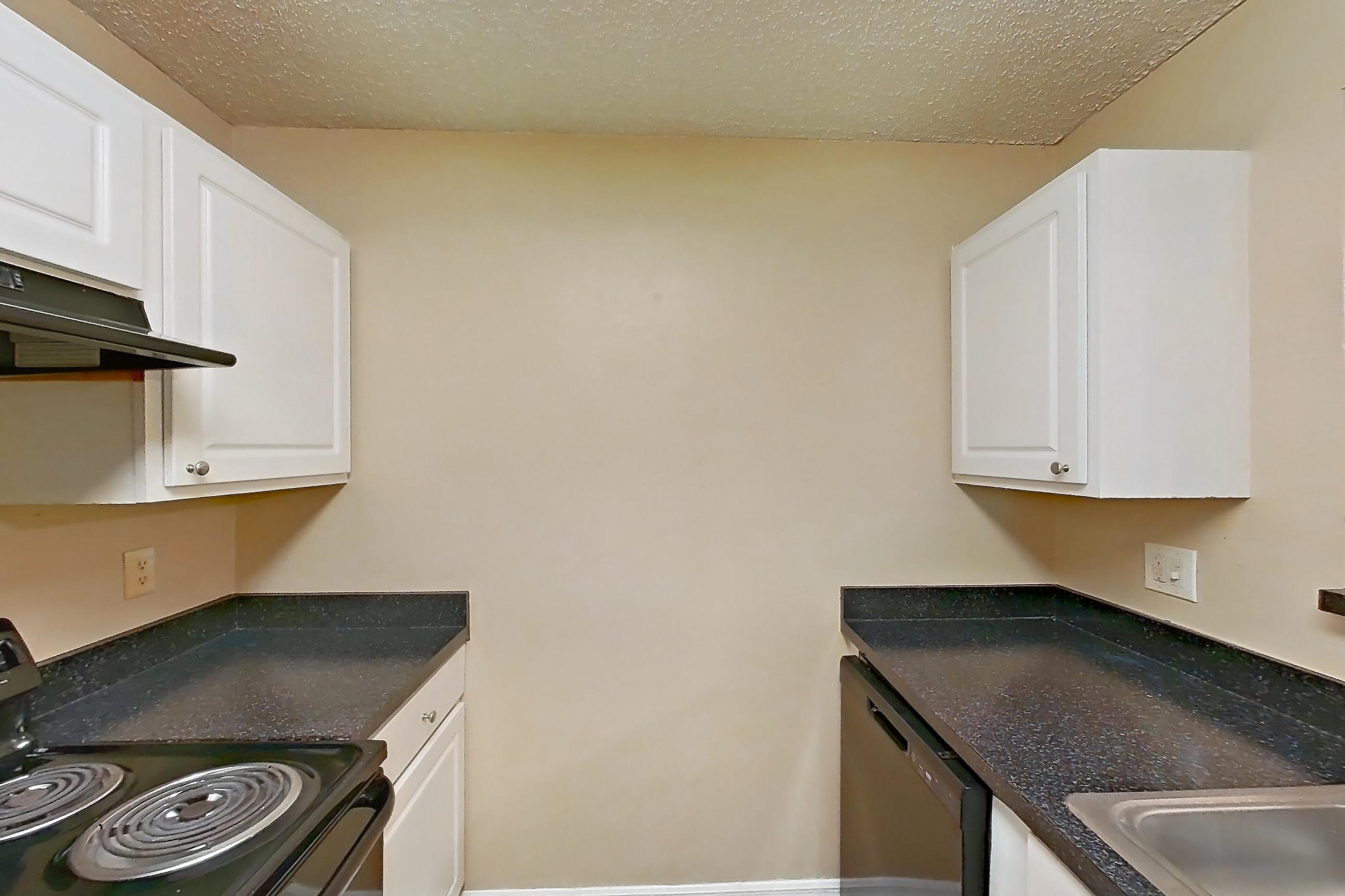 Kitchen with black appliances, dark countertops, dishwasher, electric range, light wood-finish flooring, oven/range, and range hood, Apartment 0222 at The Dawson