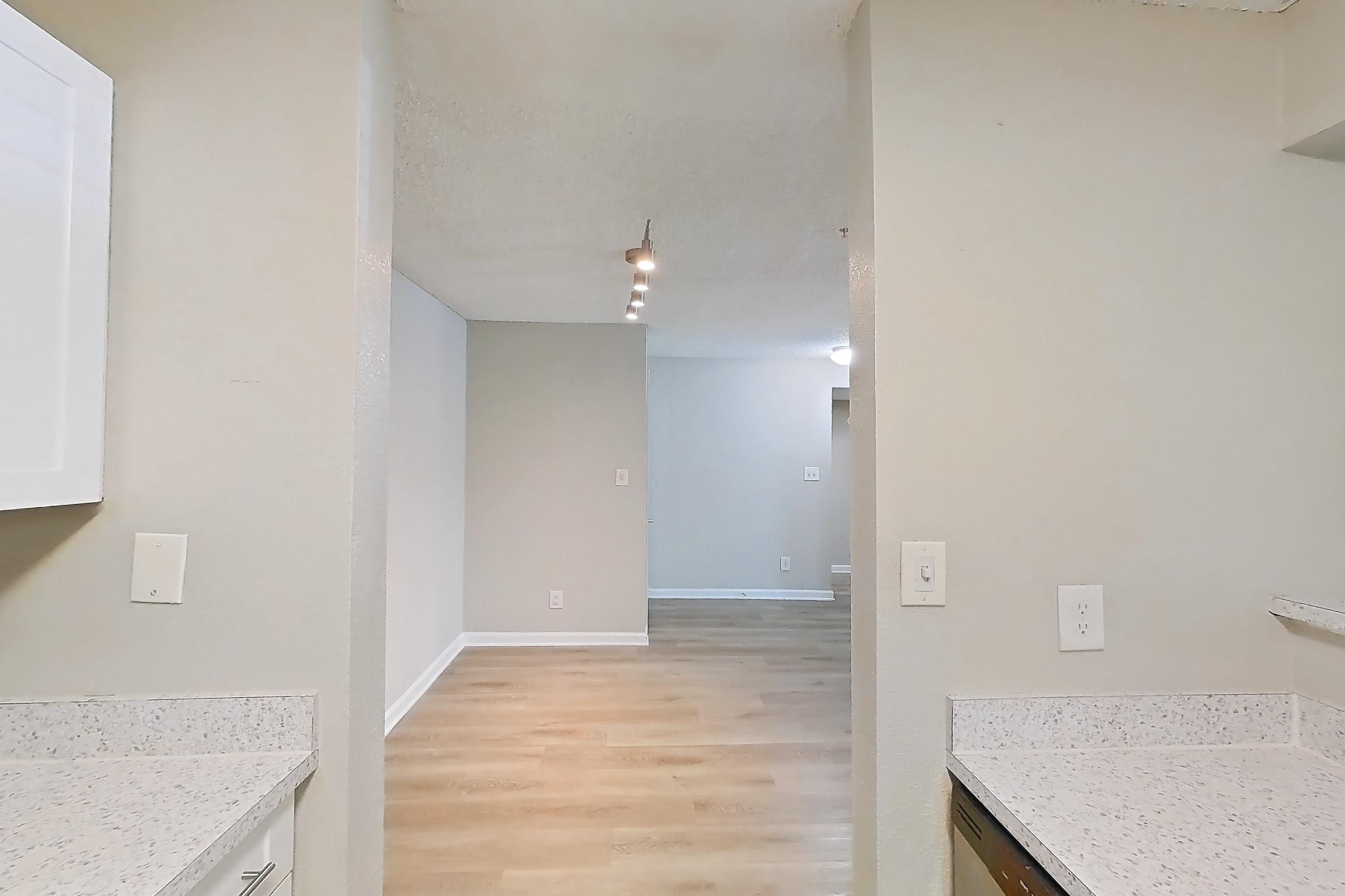 Kitchen with dishwasher, electric range, light countertops, light stone countertops, light wood-finish flooring, microwave, oven/range, refrigerator, and stainless steel appliances, Apartment 0403 at The Dawson