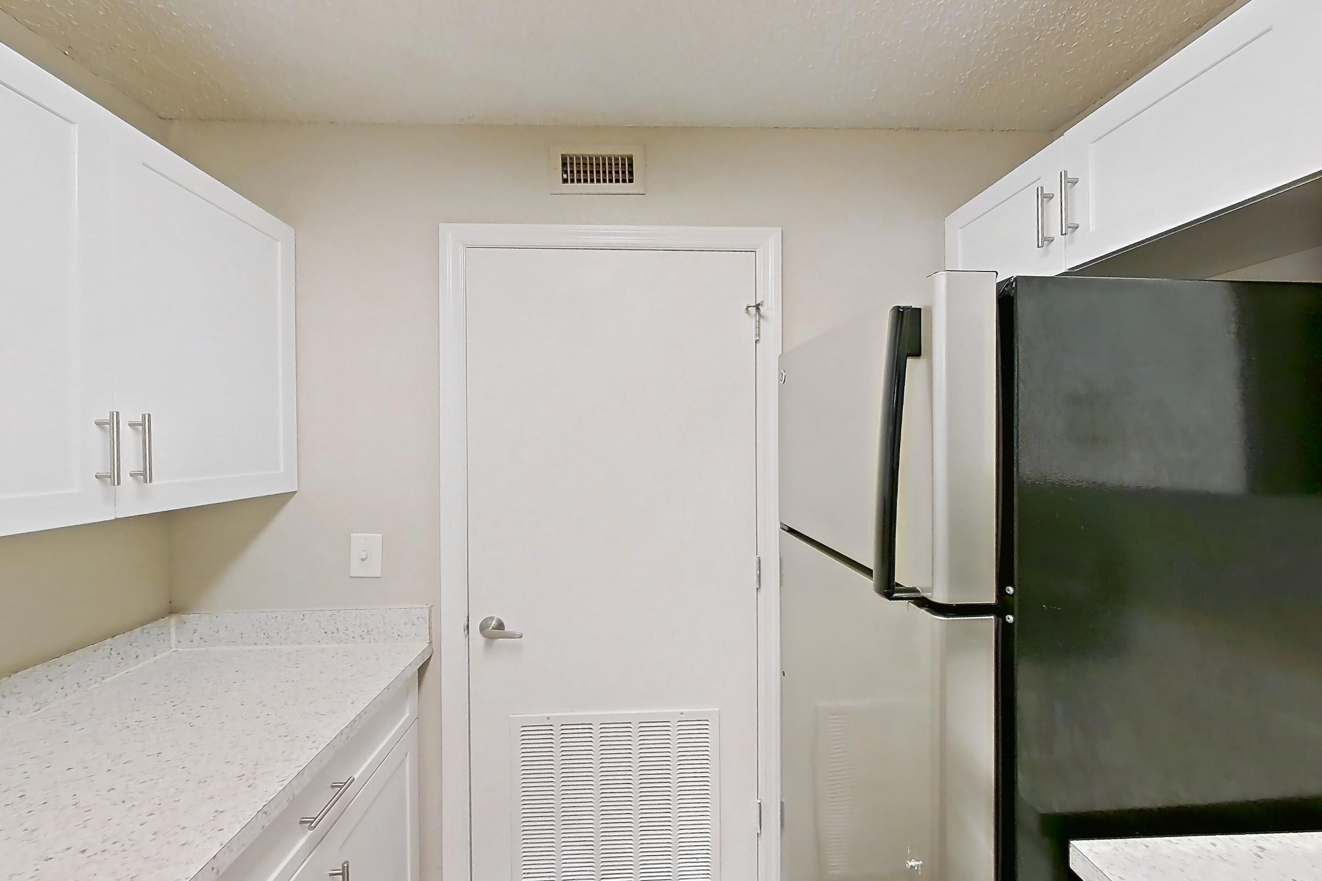 Kitchen with dishwasher, electric range, light countertops, light stone countertops, light wood-finish flooring, microwave, oven/range, refrigerator, and stainless steel appliances, Apartment 0403 at The Dawson