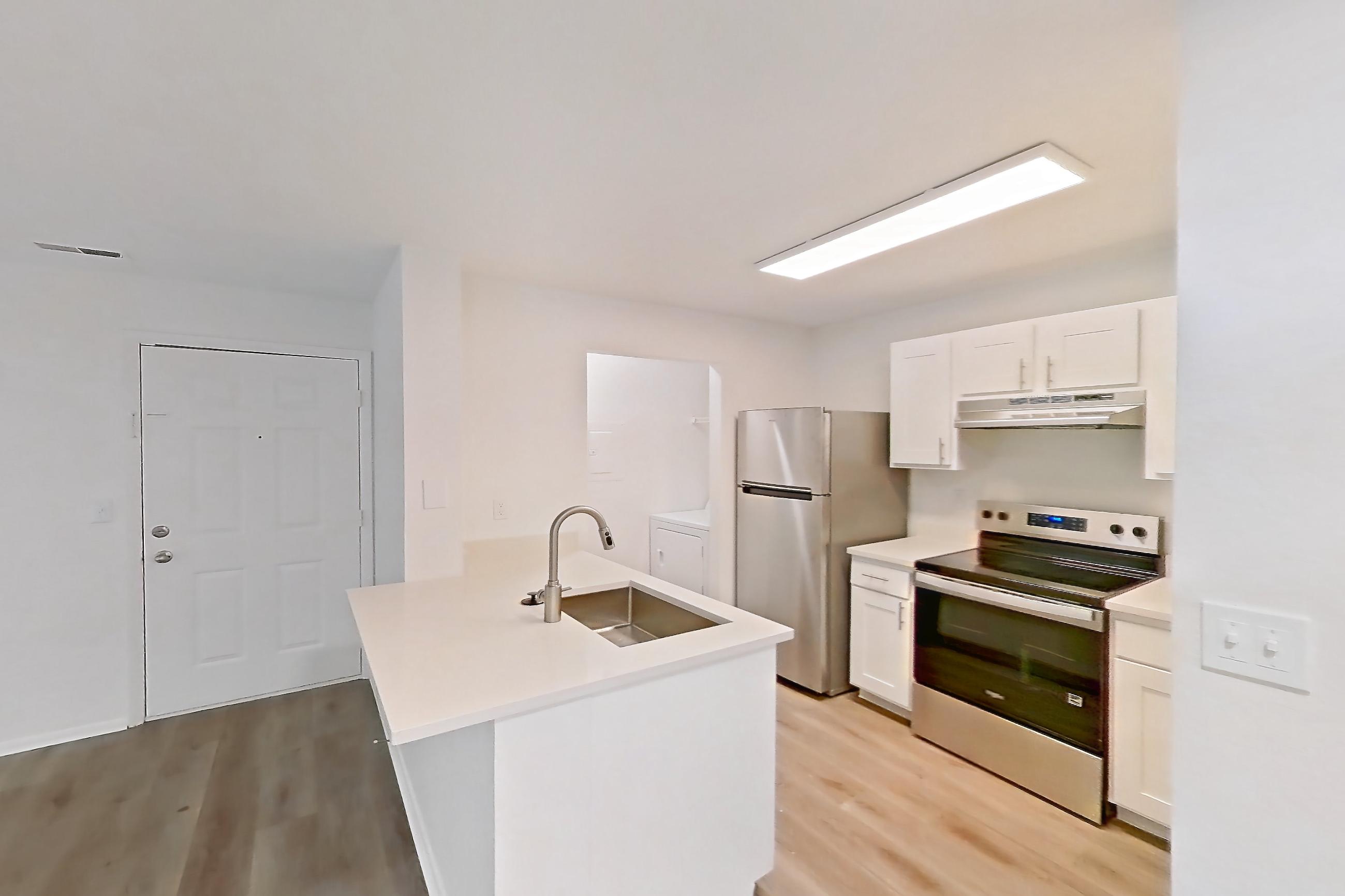Dining room with electric range, light countertops, light wood-finish flooring, oven/range, refrigerator, and stainless steel appliances, Apartment 16L at Stillwater