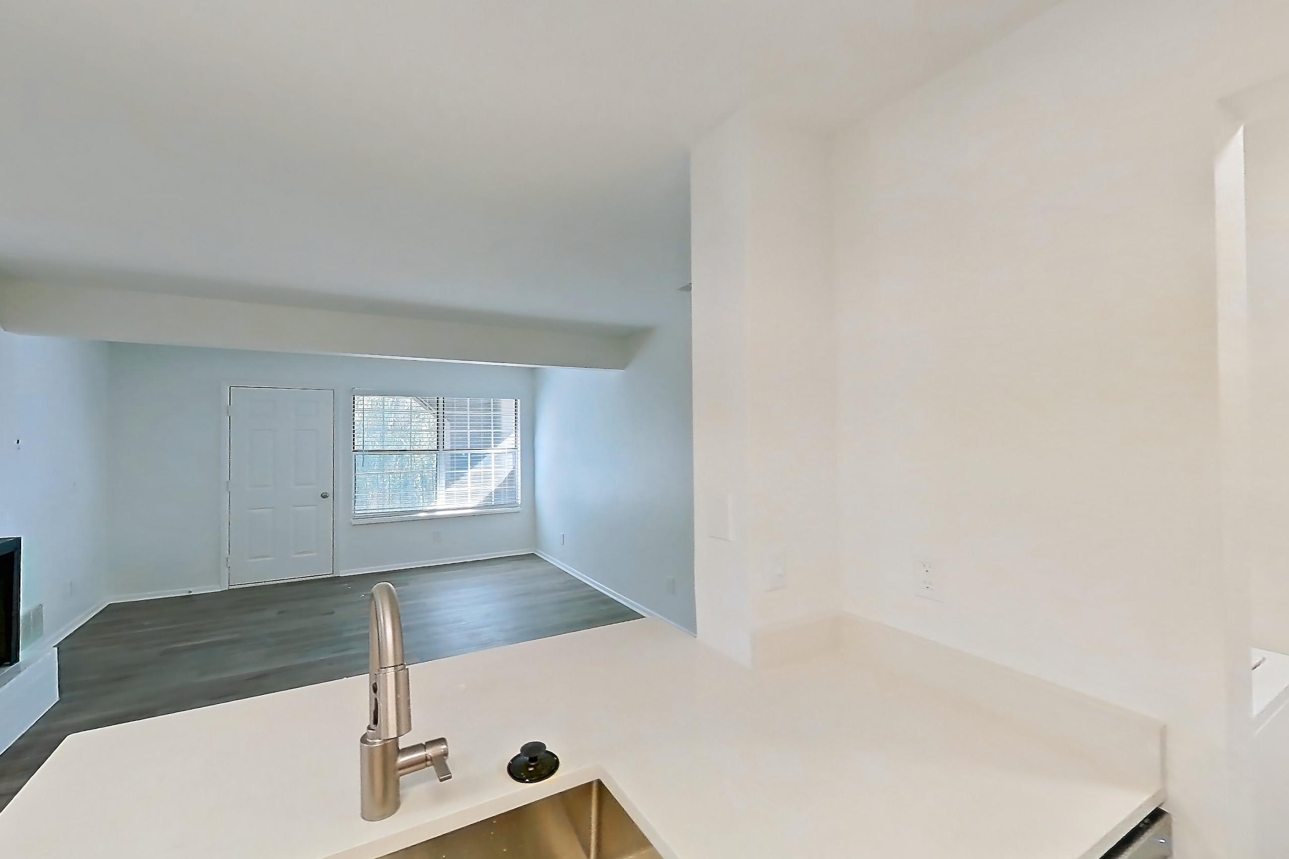 Kitchen with dishwasher, electric range, fireplace, light countertops, light wood-finish flooring, oven/range, and stainless steel appliances, Apartment 16L at Stillwater