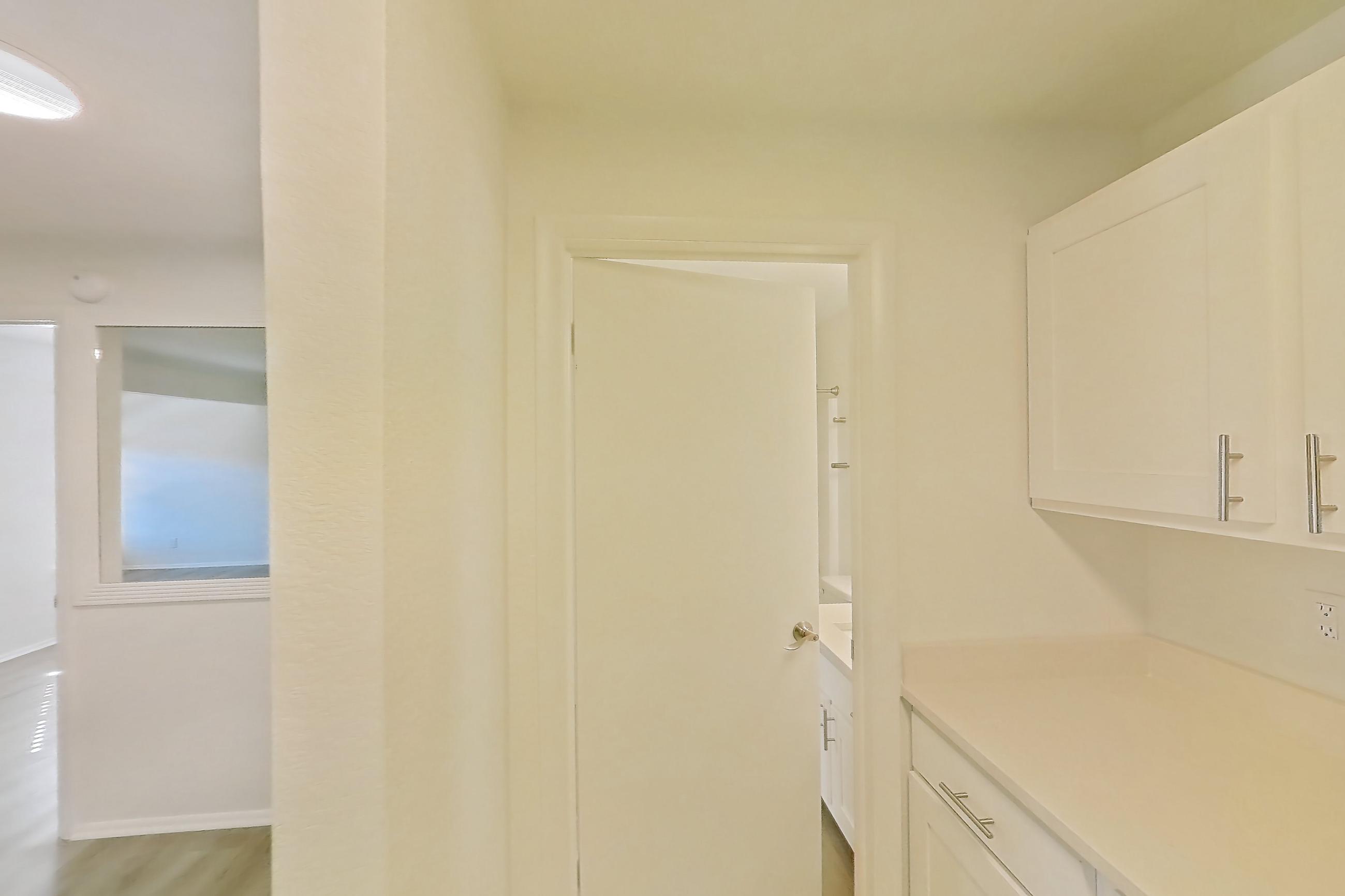 Kitchen with electric range, fireplace, light countertops, light wood-finish flooring, oven/range, refrigerator, and stainless steel appliances, Apartment 18K at Stillwater