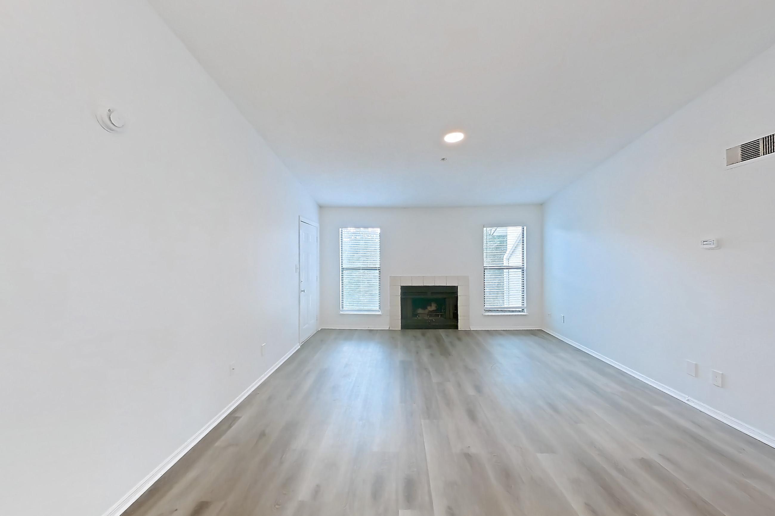 Dining room with fireplace, light wood-finish flooring, oven/range, refrigerator, stainless steel appliances, and tile fireplace, Apartment 1211 at The Dawson