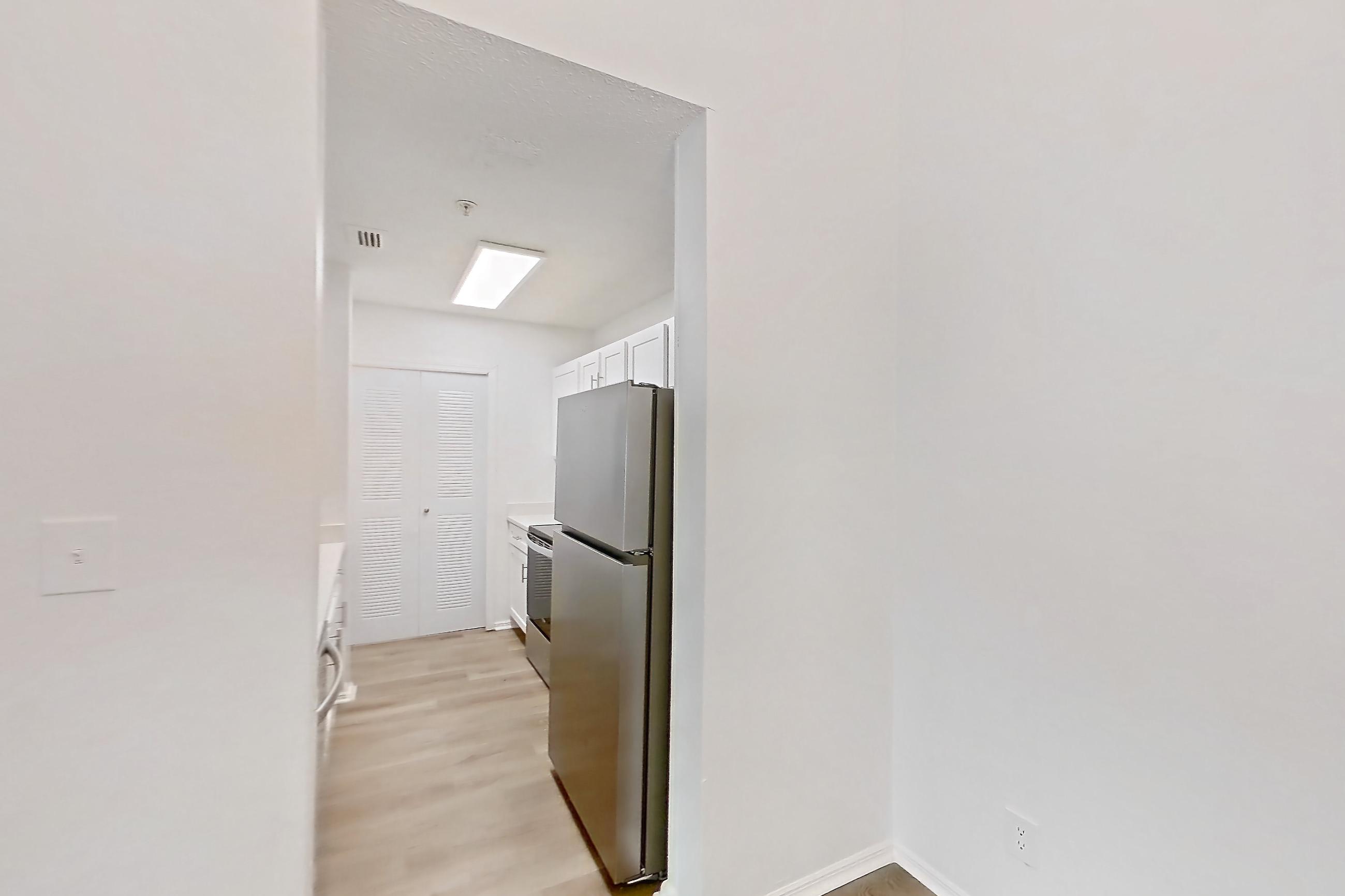 Dining room with fireplace, light wood-finish flooring, oven/range, refrigerator, stainless steel appliances, and tile fireplace, Apartment 1211 at The Dawson