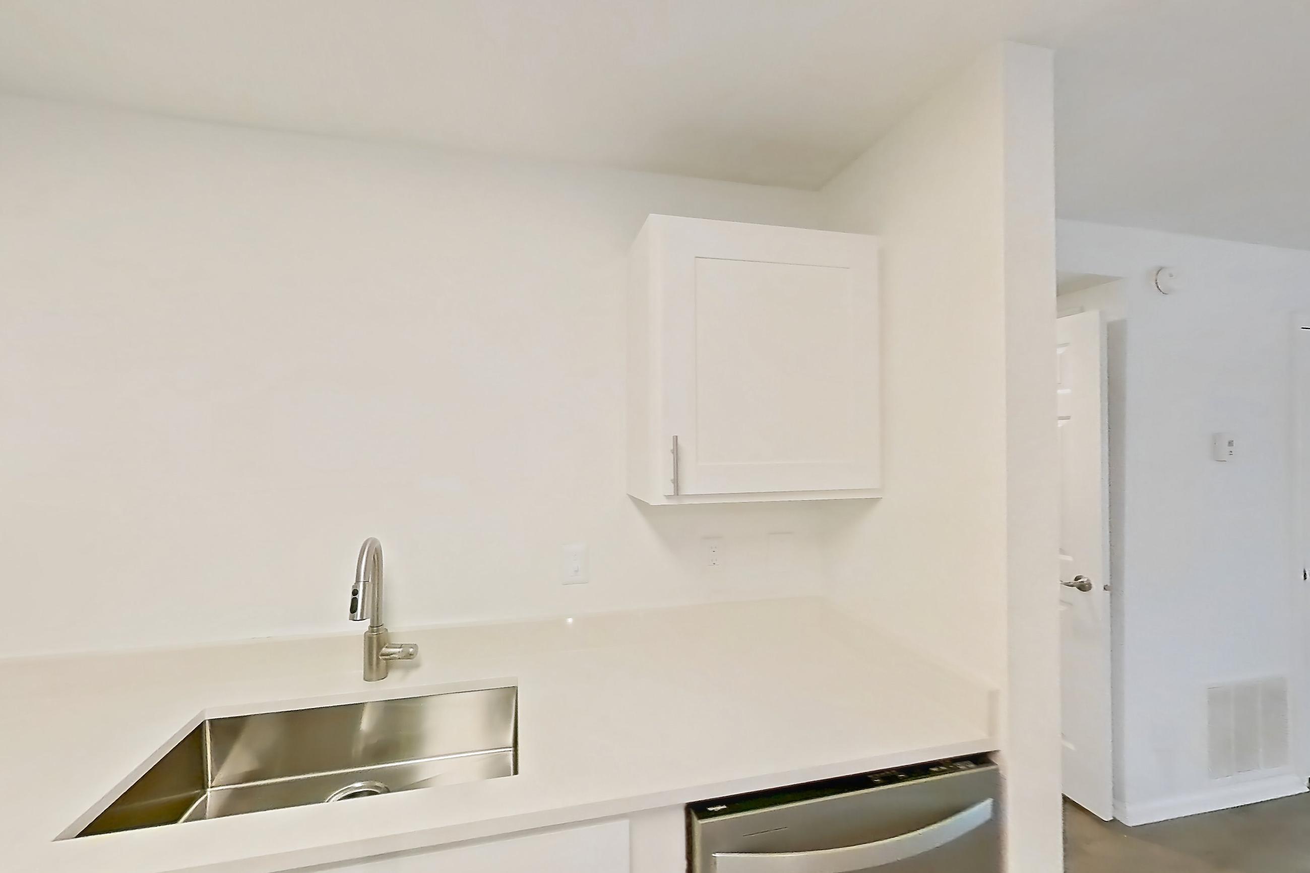 Kitchen with dishwasher, electric range, light countertops, light wood-finish flooring, microwave, oven/range, refrigerator, and stainless steel appliances, Apartment 06P at Stillwater