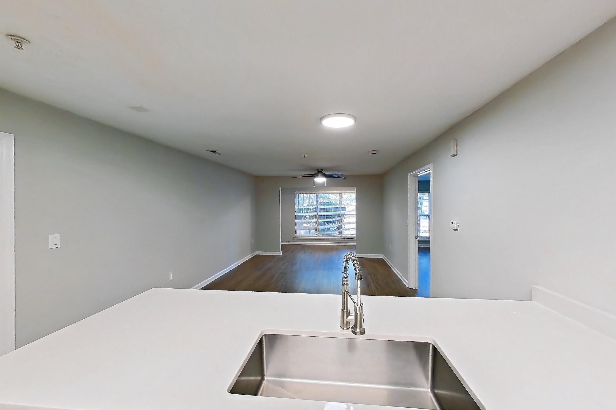 Kitchen with dishwasher, electric range, light countertops, light wood-finish flooring, microwave, oven/range, and stainless steel appliances, Apartment 6515-1C at Ashford Place