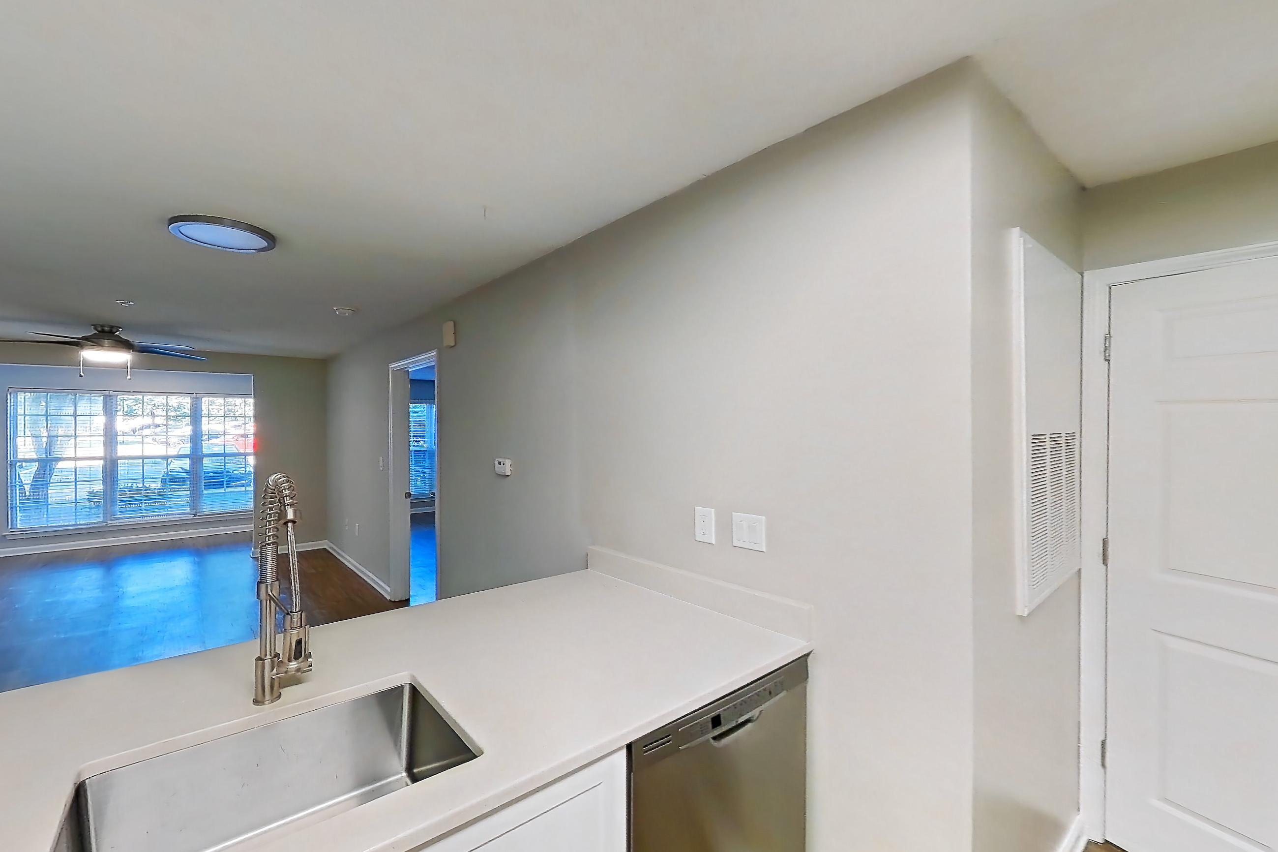 Kitchen with dishwasher, electric range, light countertops, light wood-finish flooring, microwave, oven/range, and stainless steel appliances, Apartment 6800-1C at Ashford Place