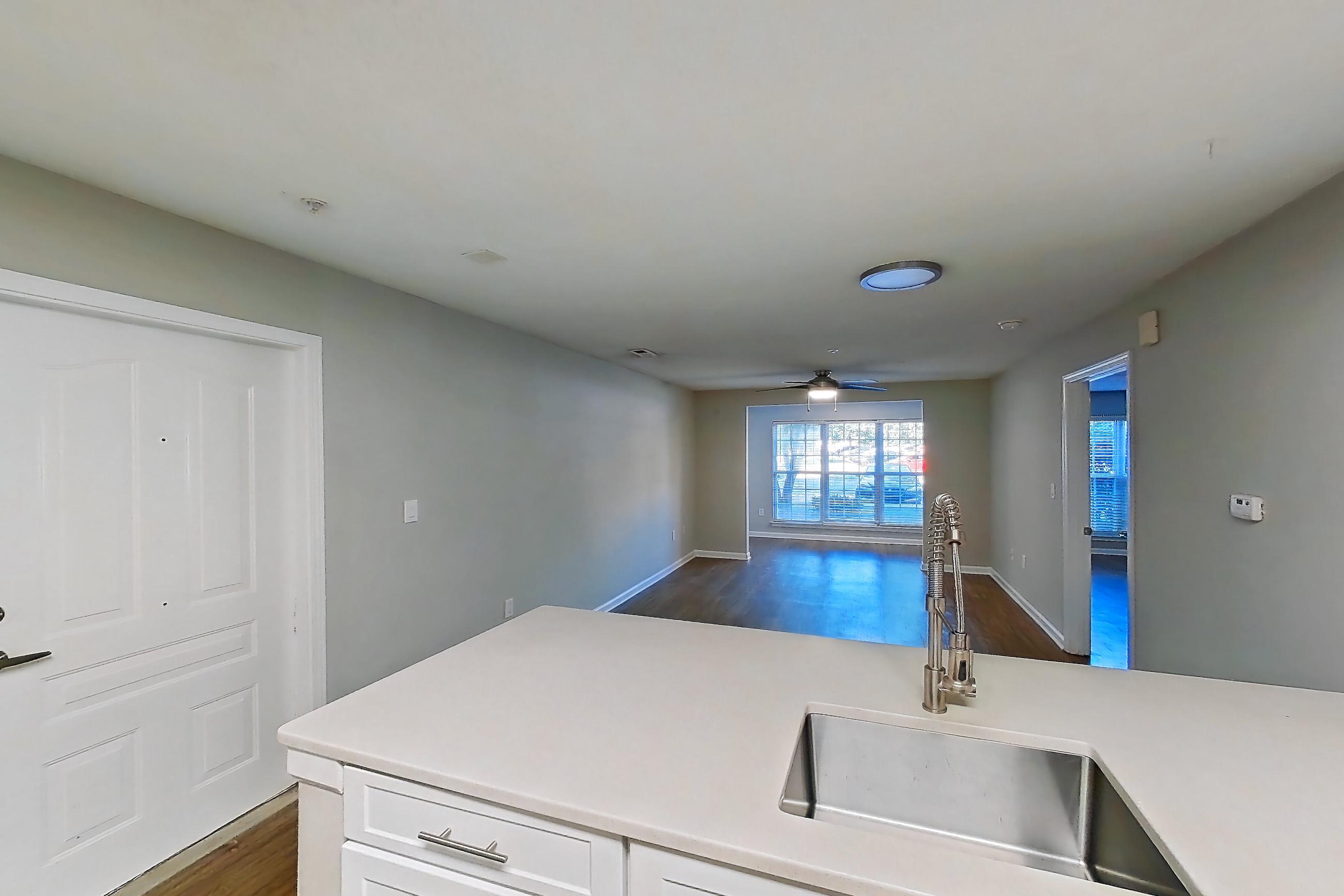 Kitchen with dishwasher, electric range, light countertops, light wood-finish flooring, microwave, oven/range, and stainless steel appliances, Apartment 6800-1C at Ashford Place