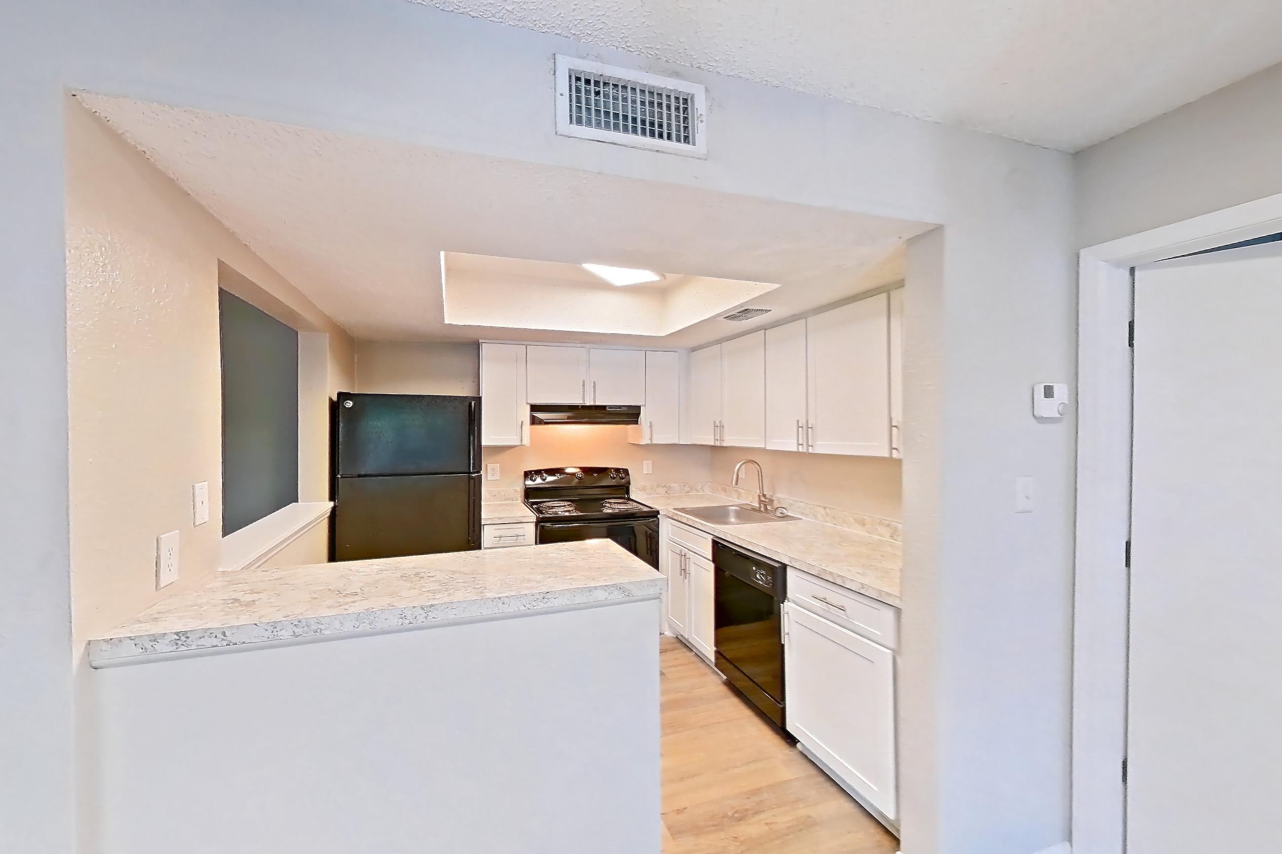 Dining room with black appliances, dishwasher, electric range, fireplace, light countertops, light wood-finish flooring, oven/range, and tile fireplace, Apartment 0616 at Beacon Hill