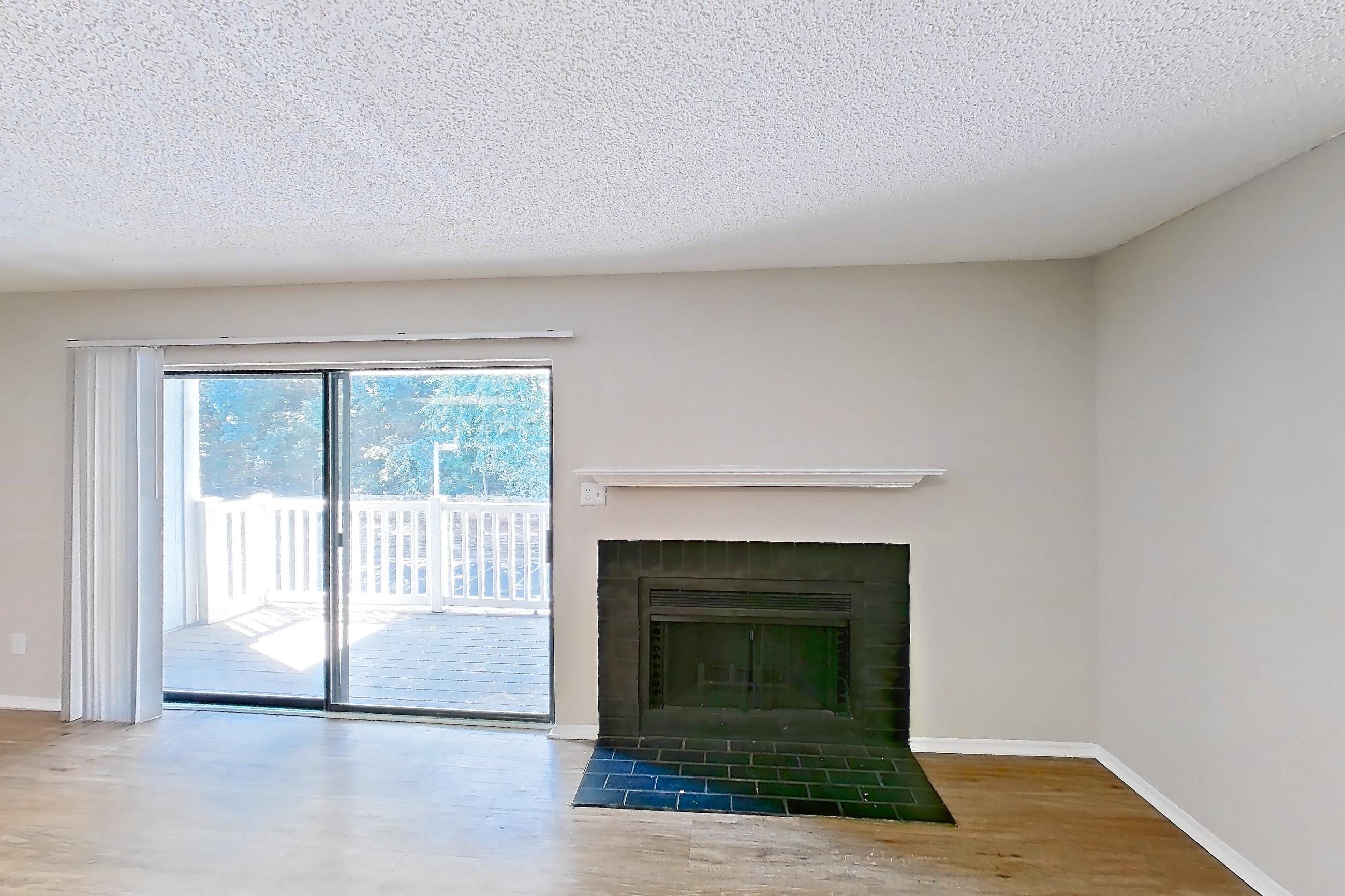 Living room with fireplace, light wood-finish flooring, refrigerator, and white appliances, Apartment 0618 at Beacon Hill