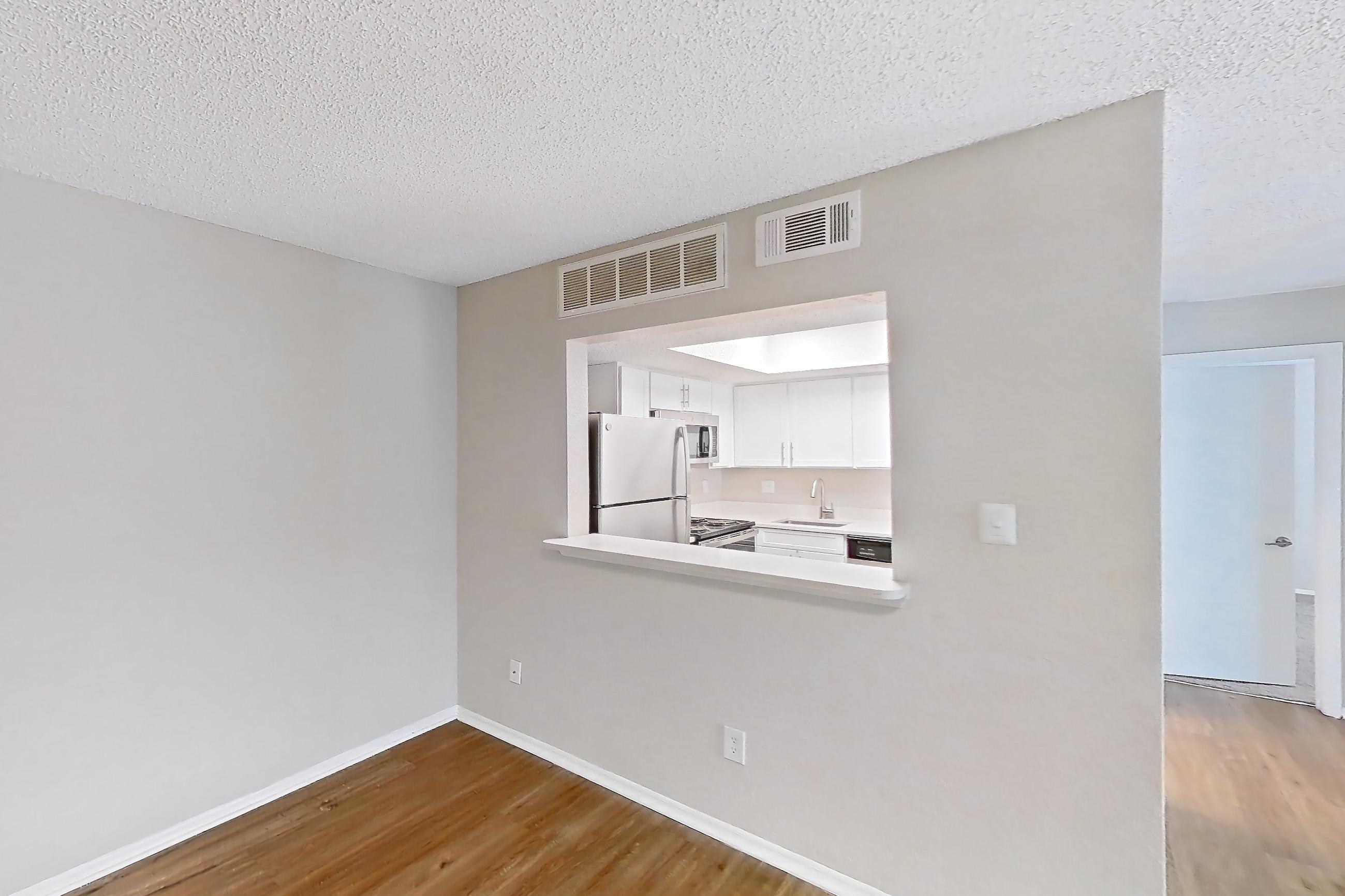 Living room with fireplace, light wood-finish flooring, refrigerator, and white appliances, Apartment 0618 at Beacon Hill