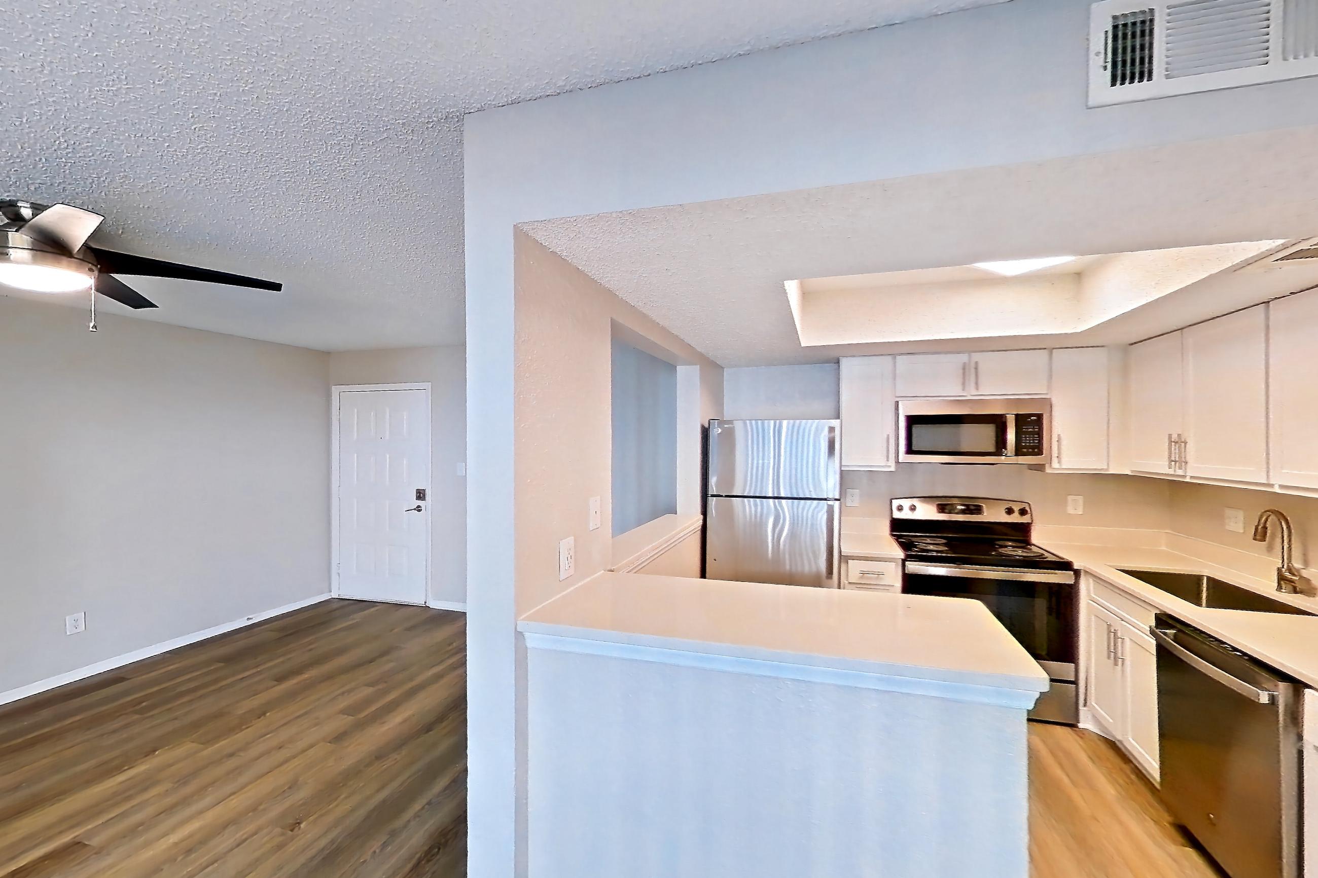 Dining room with dishwasher, electric range, light countertops, light wood-finish flooring, oven/range, refrigerator, and stainless steel appliances, Apartment 0414 at Beacon Hill