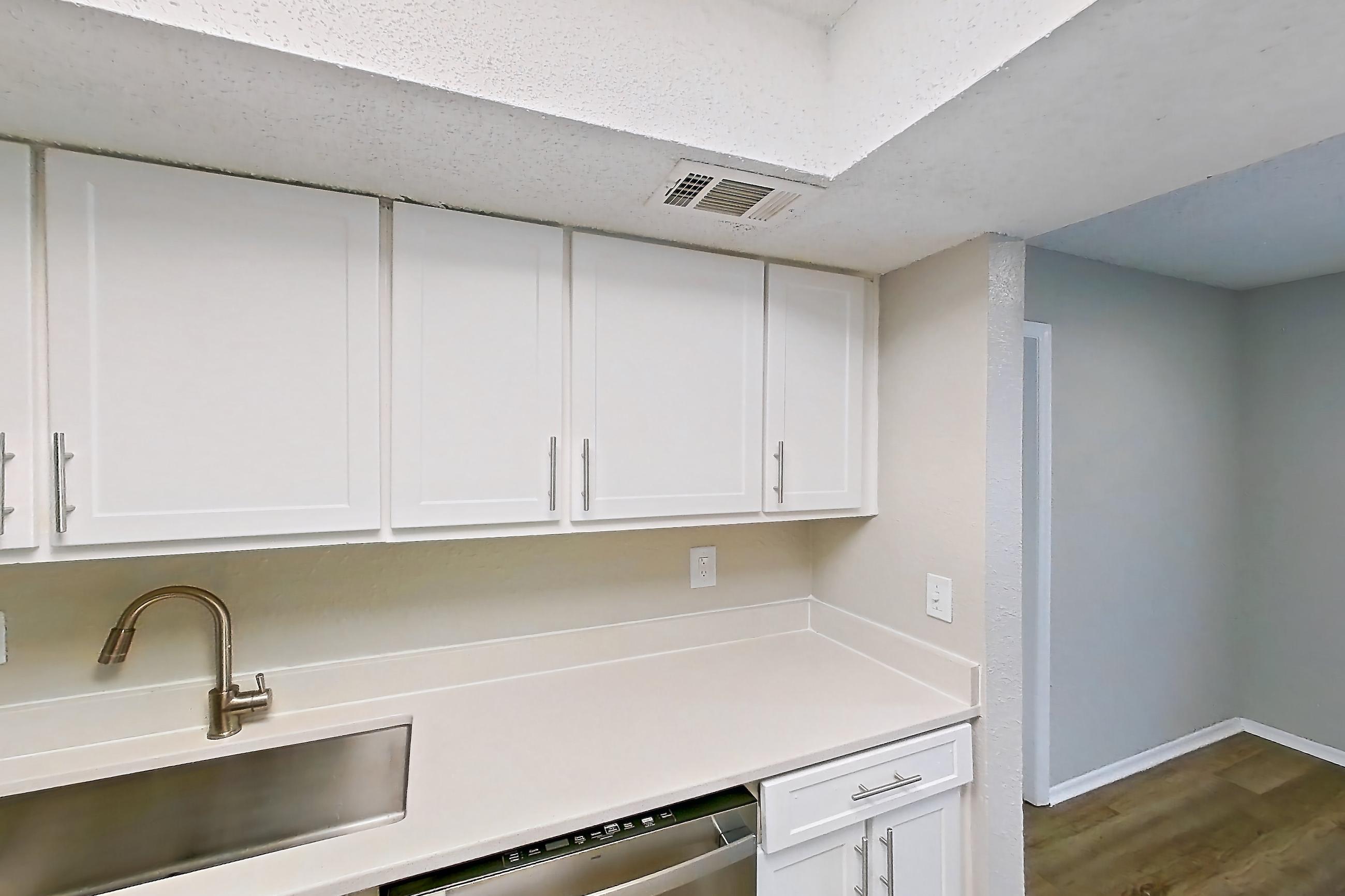 Kitchen with dishwasher, electric range, light countertops, light wood-finish flooring, microwave, oven/range, refrigerator, and stainless steel appliances, Apartment 0414 at Beacon Hill