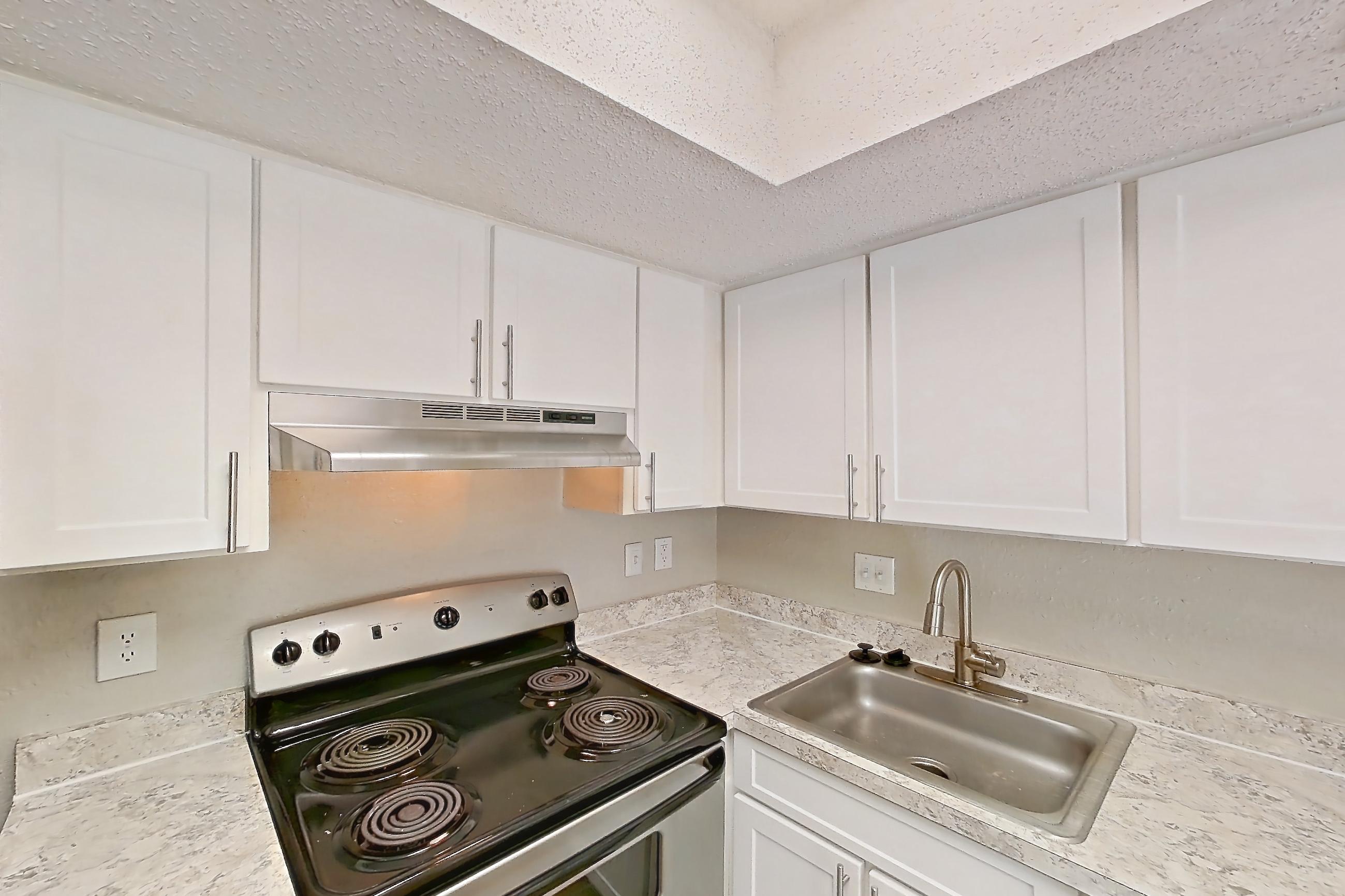 Kitchen with dishwasher, electric range, light countertops, light wood-finish flooring, oven/range, refrigerator, and stainless steel appliances, Apartment 0610 at Beacon Hill