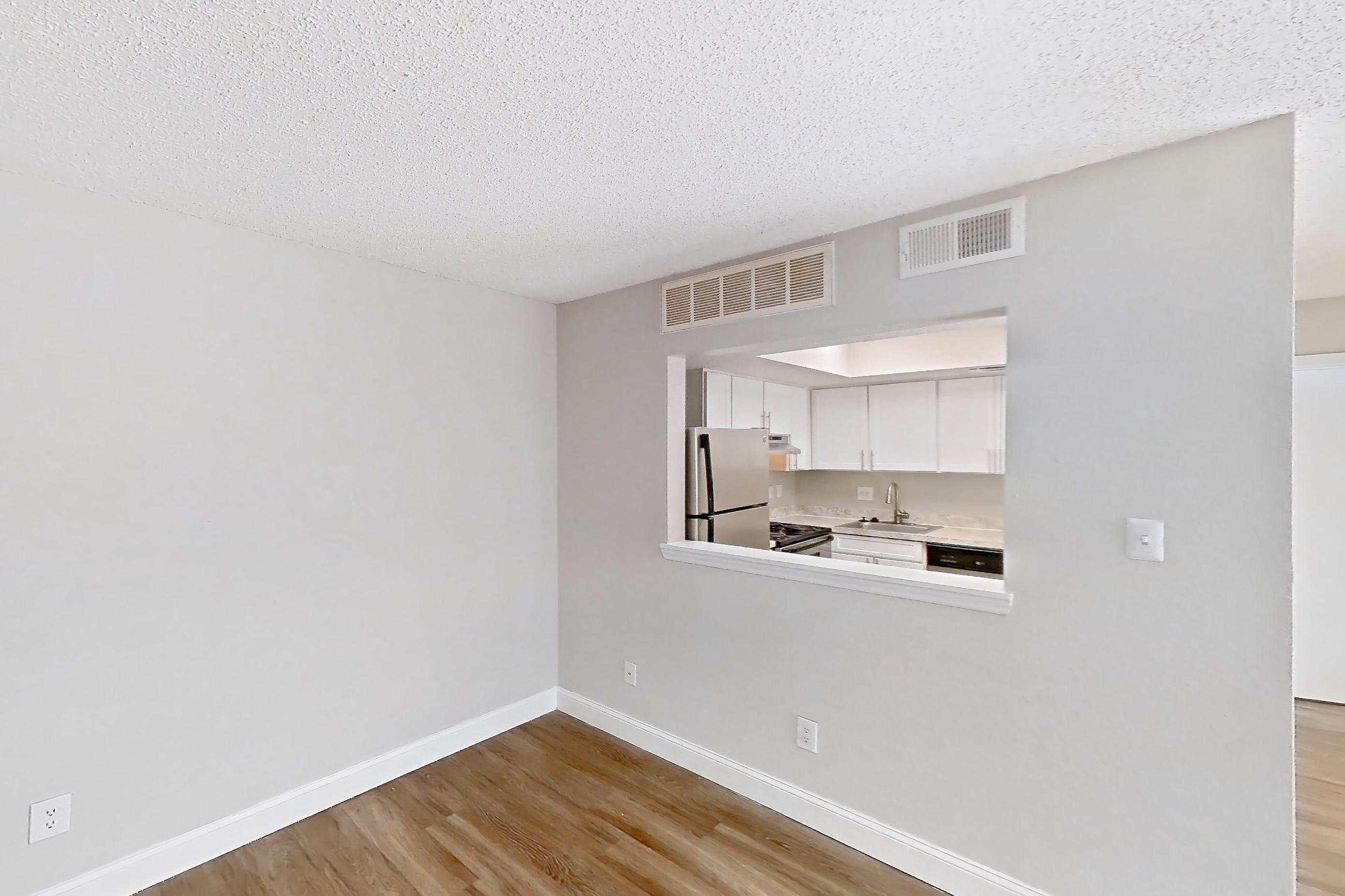 Living room with dishwasher, light wood-finish flooring, oven/range, refrigerator, stainless steel appliances, and white appliances, Apartment 0610 at Beacon Hill