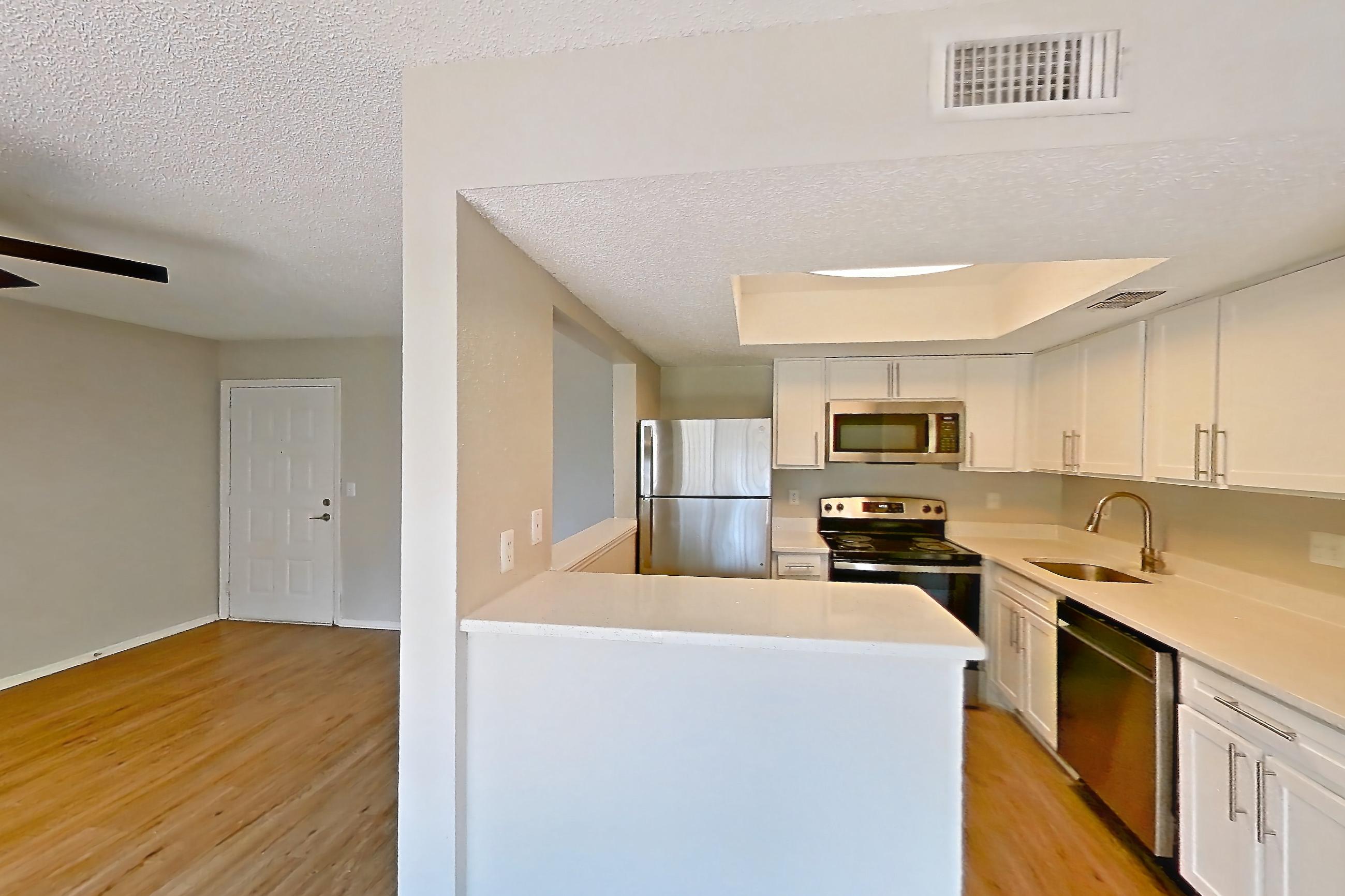 Dining room with dishwasher, electric range, light stone countertops, light wood-finish flooring, microwave, oven/range, refrigerator, and stainless steel appliances, Apartment 1102 at Beacon Hill
