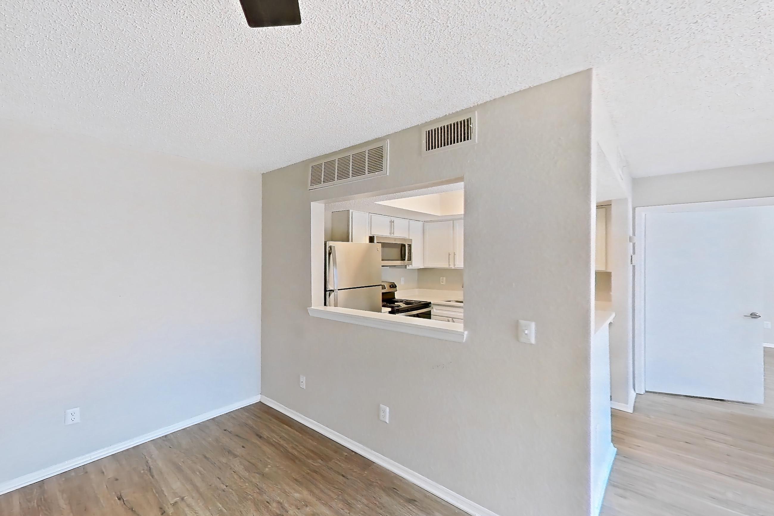 Living room with dark wood-finish flooring, light wood-finish flooring, oven/range, refrigerator, and stainless steel appliances, Apartment 1102 at Beacon Hill
