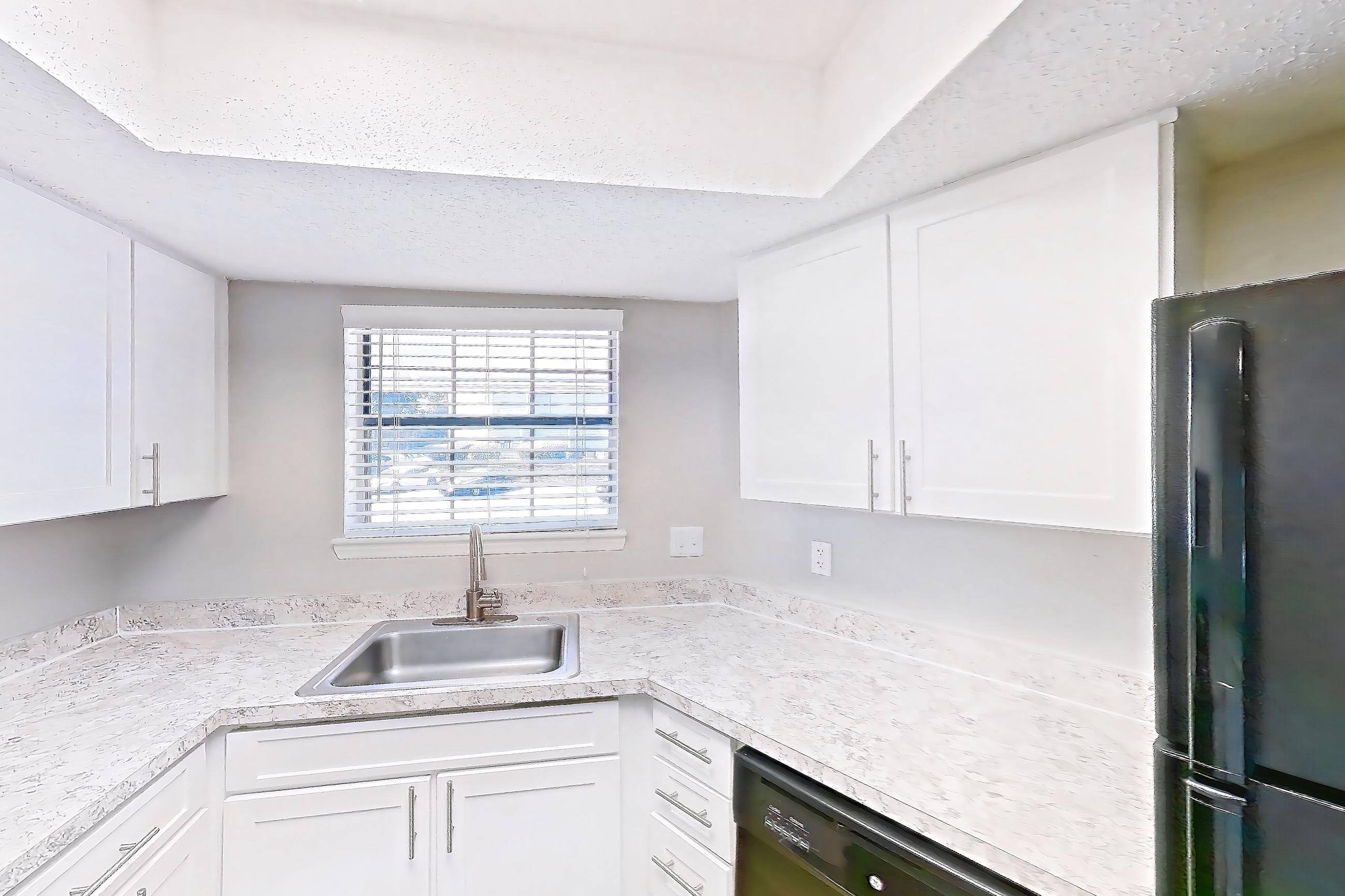 Kitchen with black appliances, dishwasher, electric range, light countertops, light wood-finish flooring, oven/range, refrigerator, and stainless steel appliances, Apartment 0505 at Beacon Hill