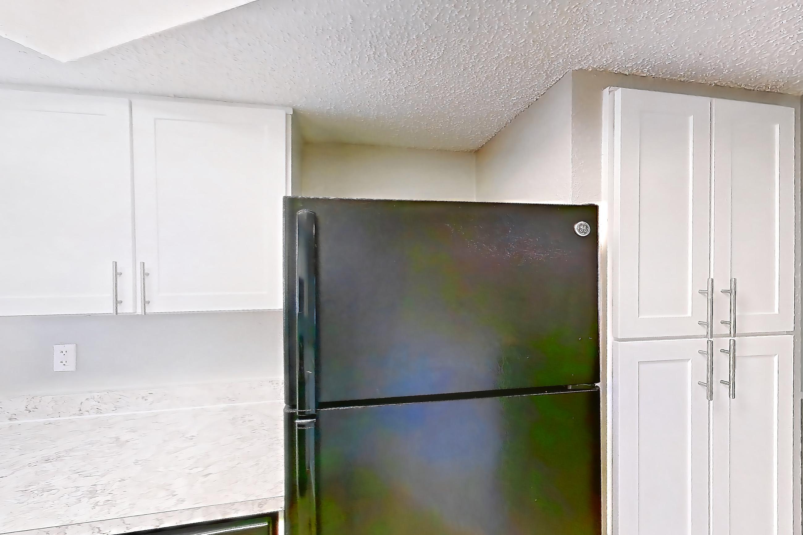 Kitchen with black appliances, dishwasher, electric range, light countertops, light wood-finish flooring, oven/range, refrigerator, and stainless steel appliances, Apartment 0505 at Beacon Hill