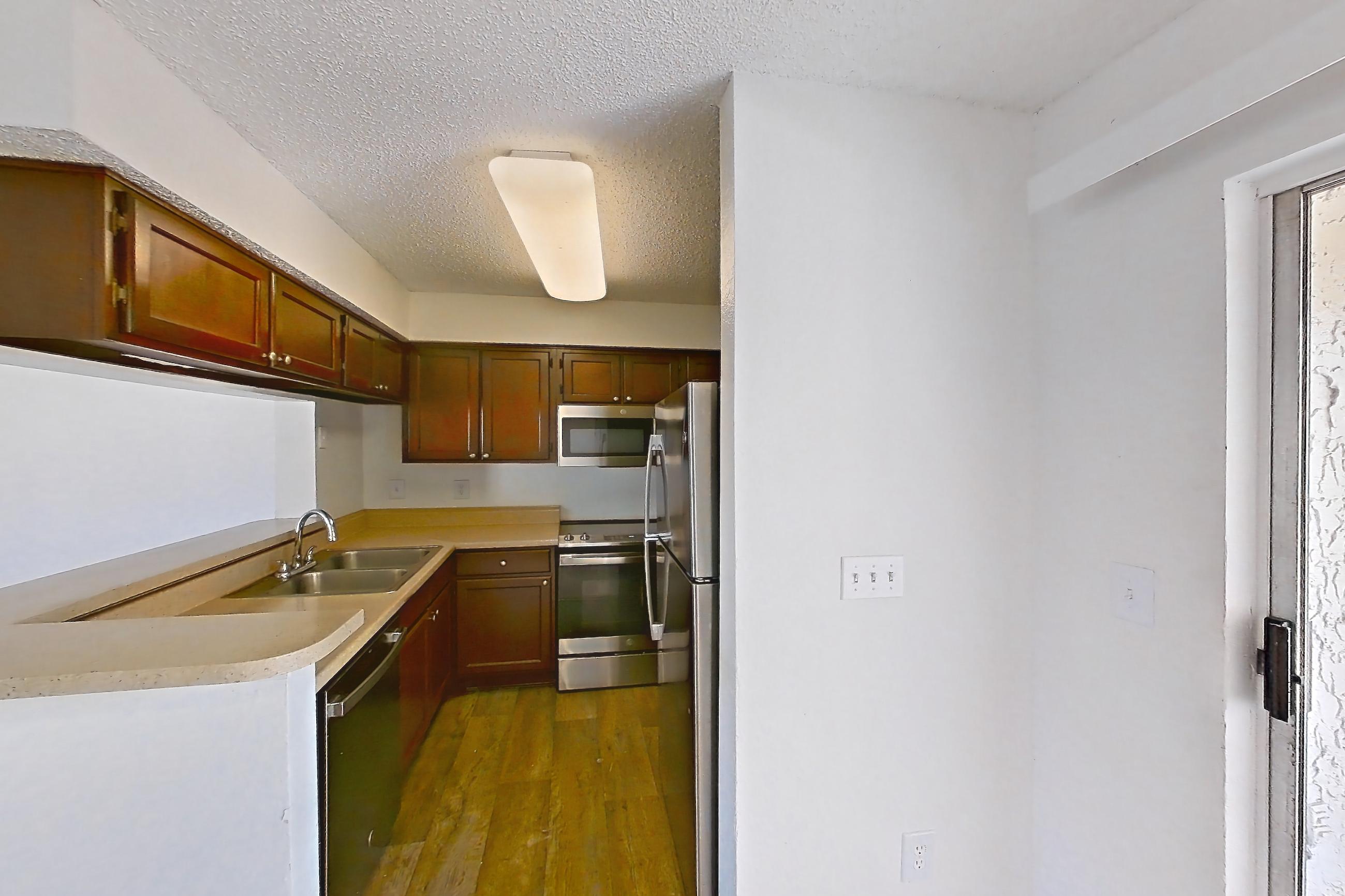 Dining room with dark carpet, dishwasher, light countertops, oven/range, refrigerator, and stainless steel appliances, Apartment 20-0715 at Brookwood Club