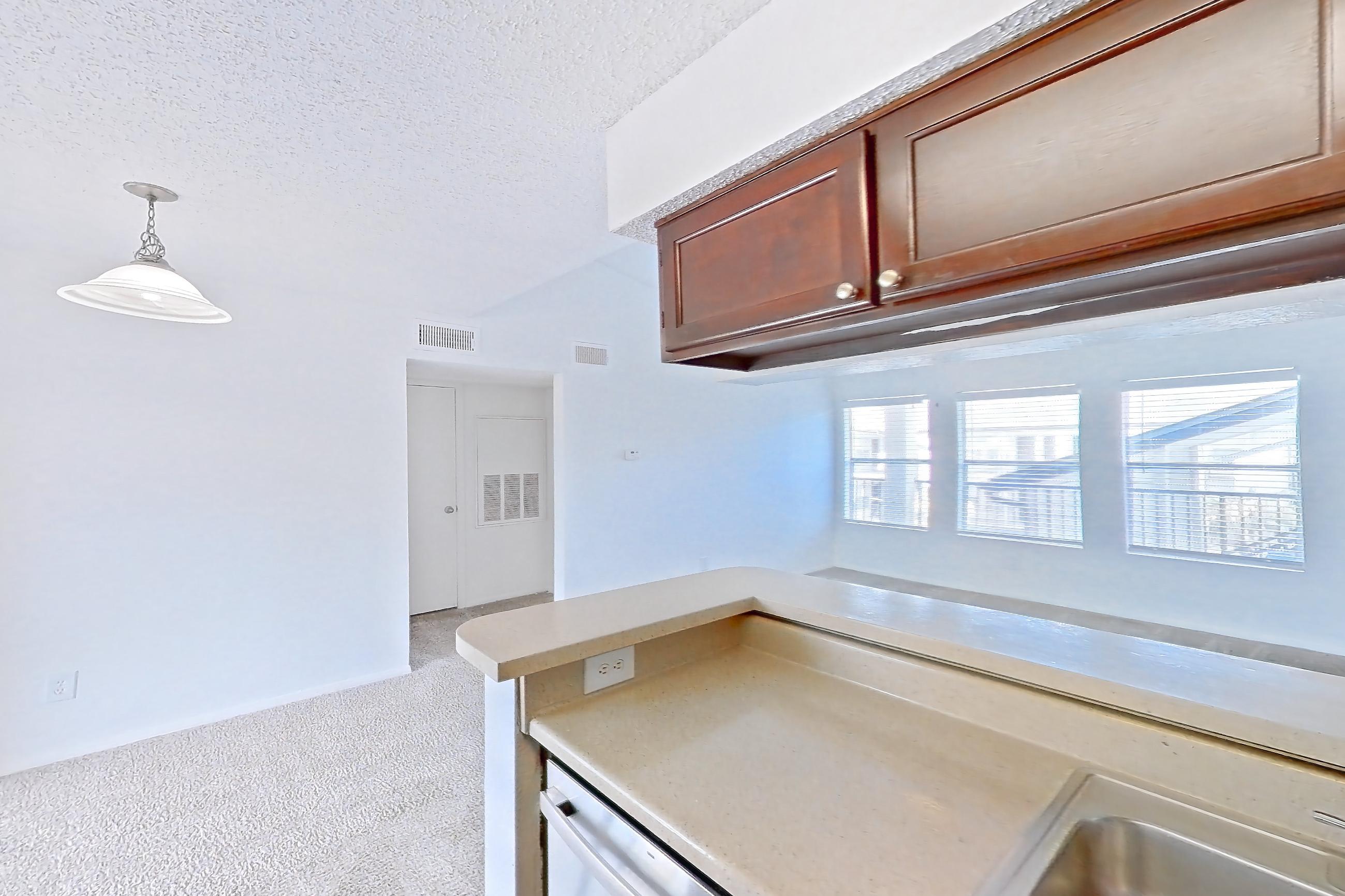 Kitchen with dishwasher, electric range, light countertops, light wood-finish flooring, microwave, oven/range, and stainless steel appliances, Apartment 20-0715 at Brookwood Club