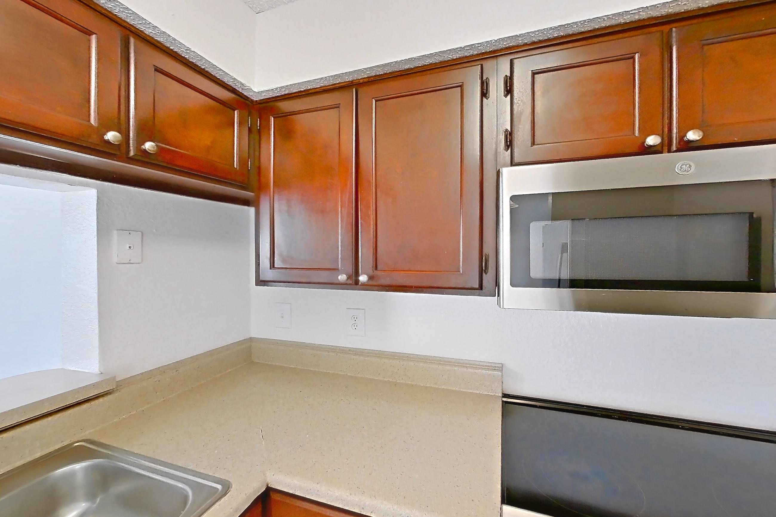 Kitchen with dishwasher, electric range, light countertops, light wood-finish flooring, microwave, oven/range, and stainless steel appliances, Apartment 20-0715 at Brookwood Club