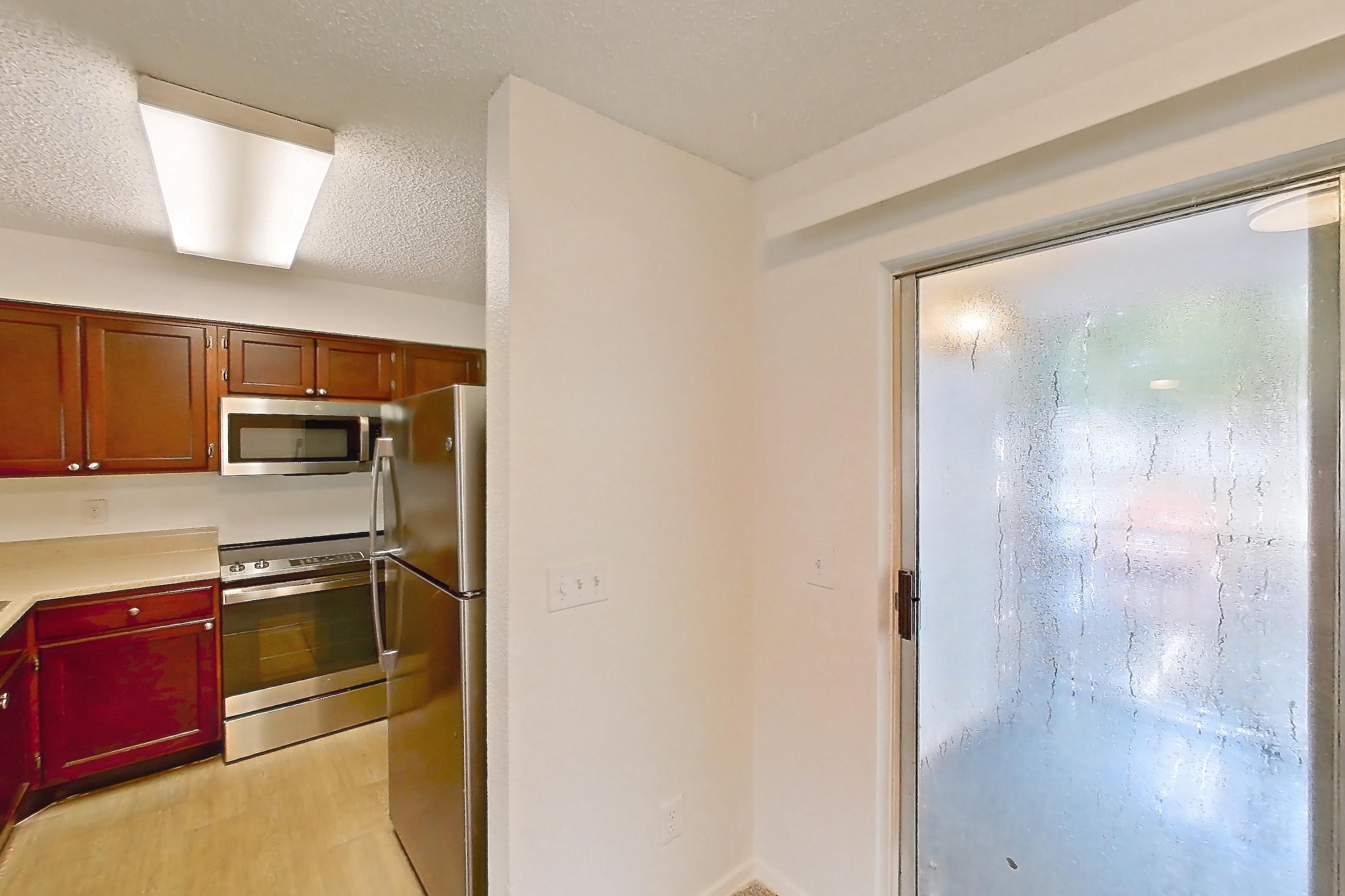 Dining room with dishwasher, electric range, light carpet, light countertops, oven/range, refrigerator, and stainless steel appliances, Apartment 10-0109 at Brookwood Club