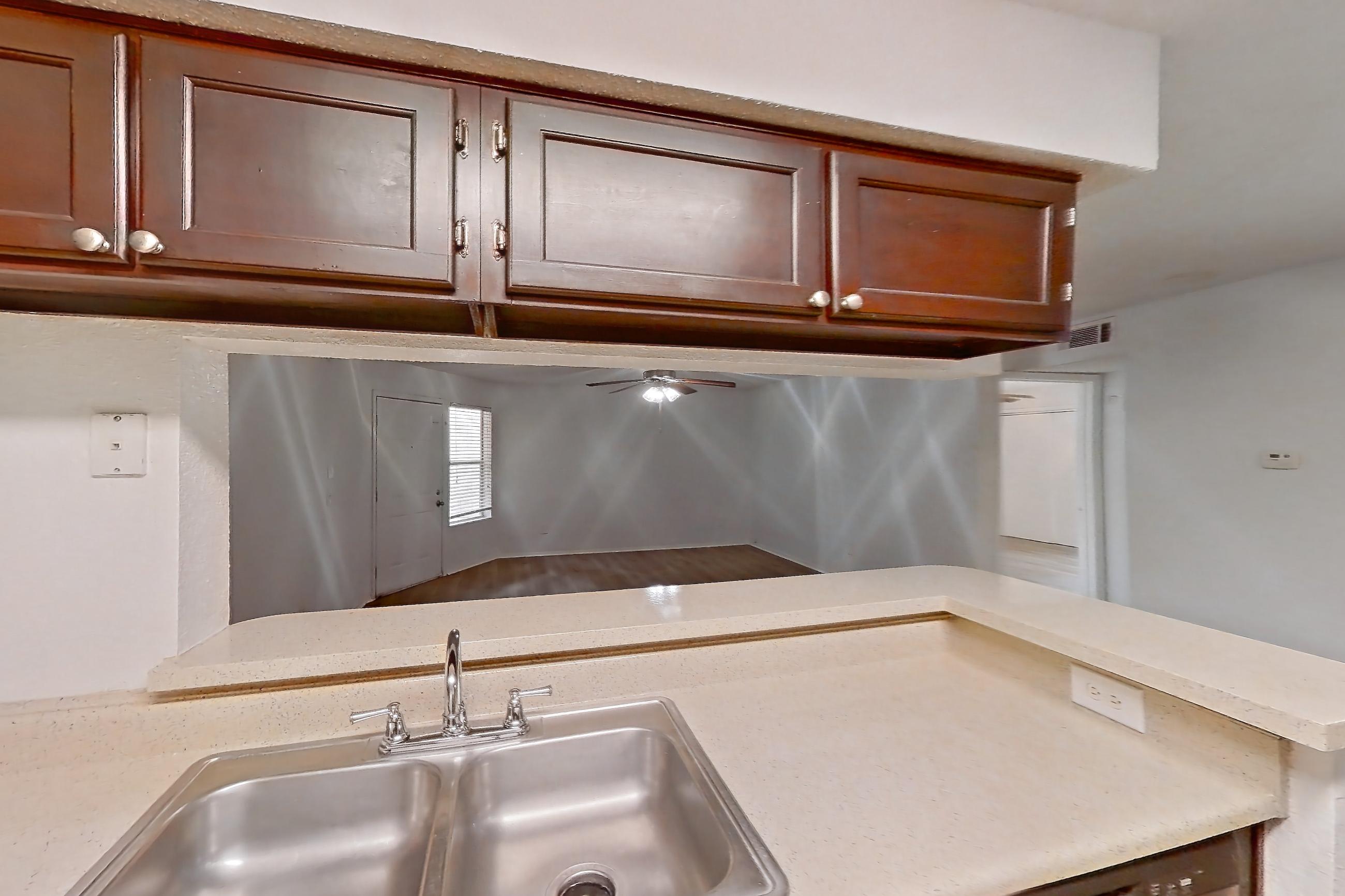 Kitchen with dishwasher, electric range, light countertops, light wood-finish flooring, oven/range, range hood, refrigerator, and stainless steel appliances, Apartment 10-1102 at Brookwood Club