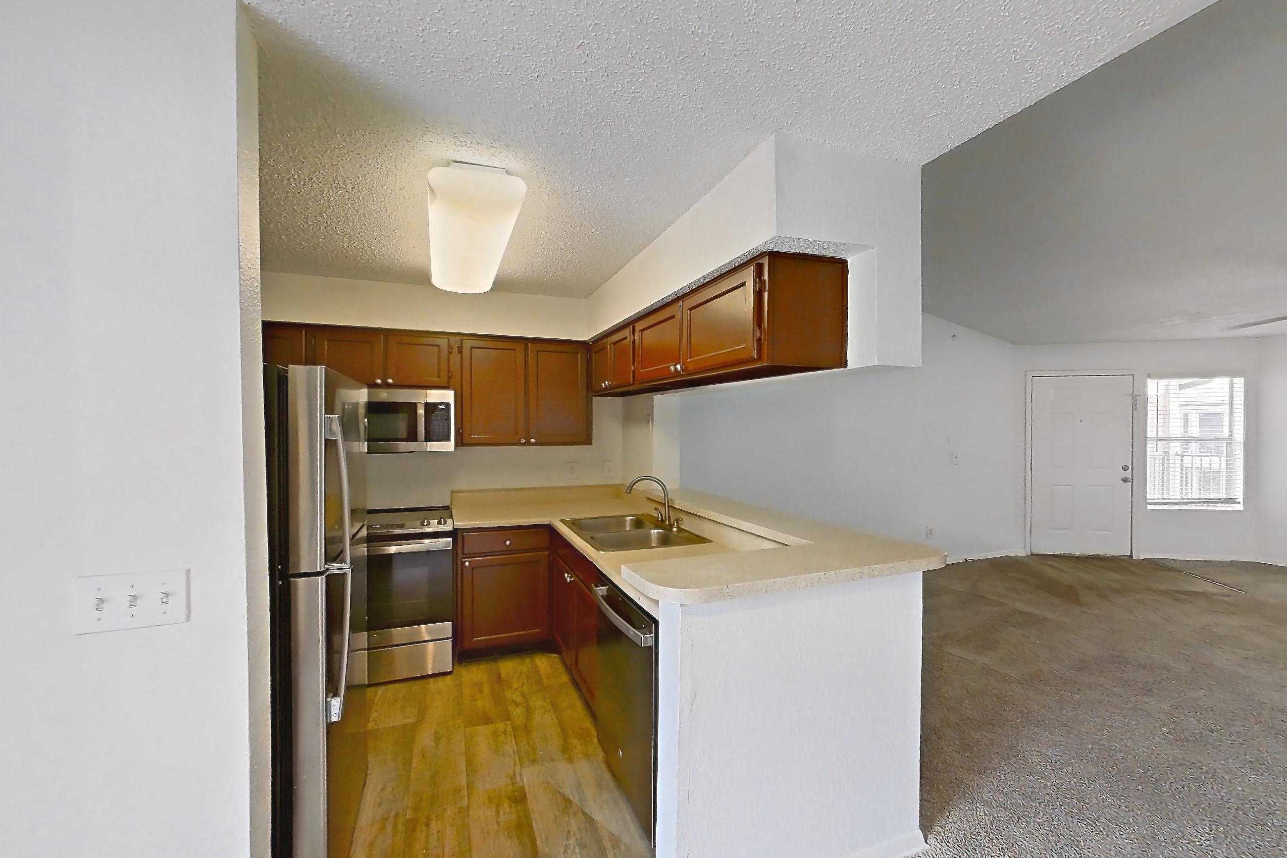 Dining room with dishwasher, electric range, light carpet, light countertops, oven/range, refrigerator, and stainless steel appliances, Apartment 20-0817 at Brookwood Club