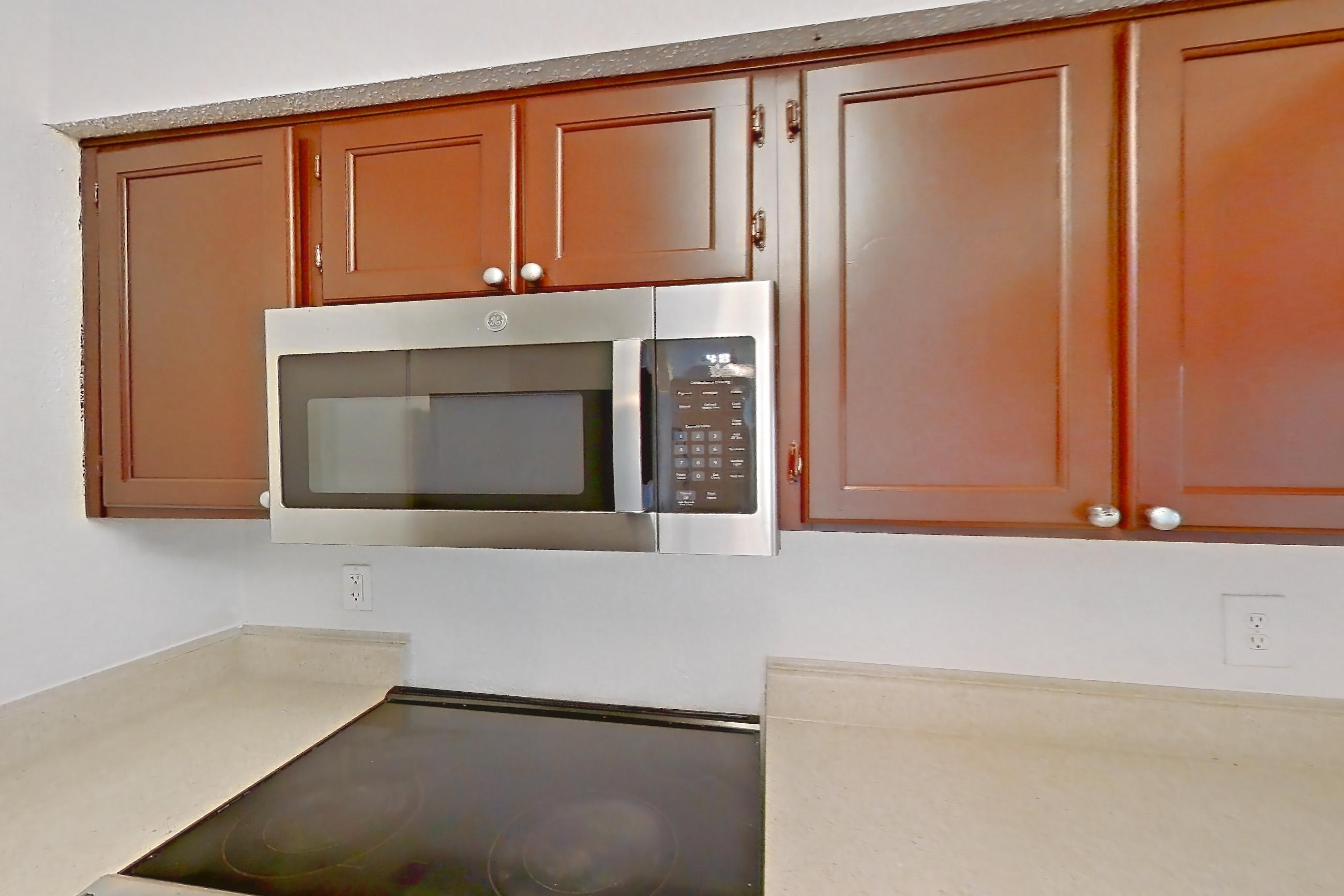 Kitchen with dishwasher, electric range, light countertops, light wood-finish flooring, microwave, oven/range, refrigerator, stainless steel appliances, and white appliances, Apartment 20-0817 at Brookwood Club