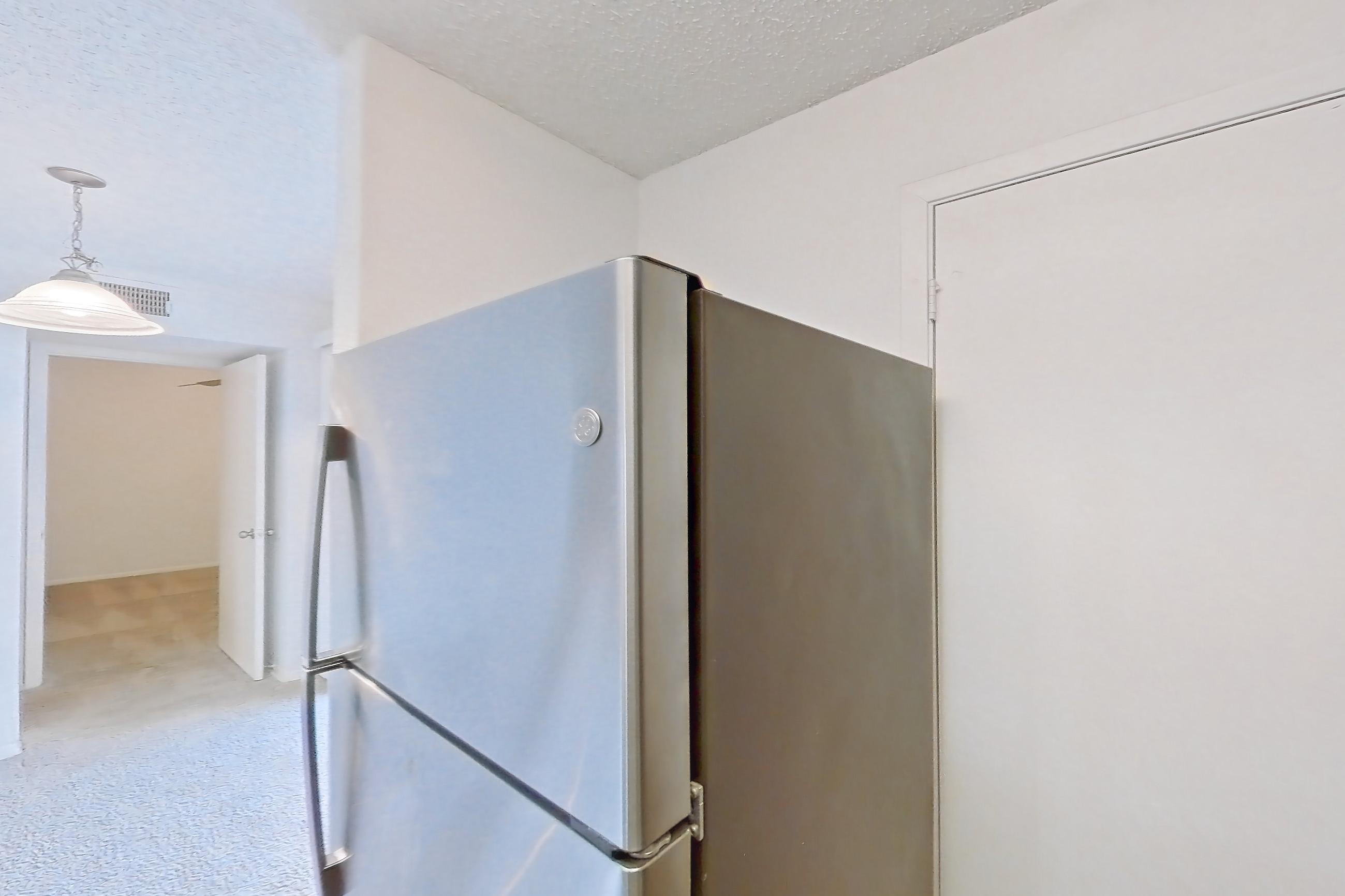Kitchen with dishwasher, electric range, light countertops, light wood-finish flooring, microwave, oven/range, refrigerator, stainless steel appliances, and white appliances, Apartment 20-0817 at Brookwood Club