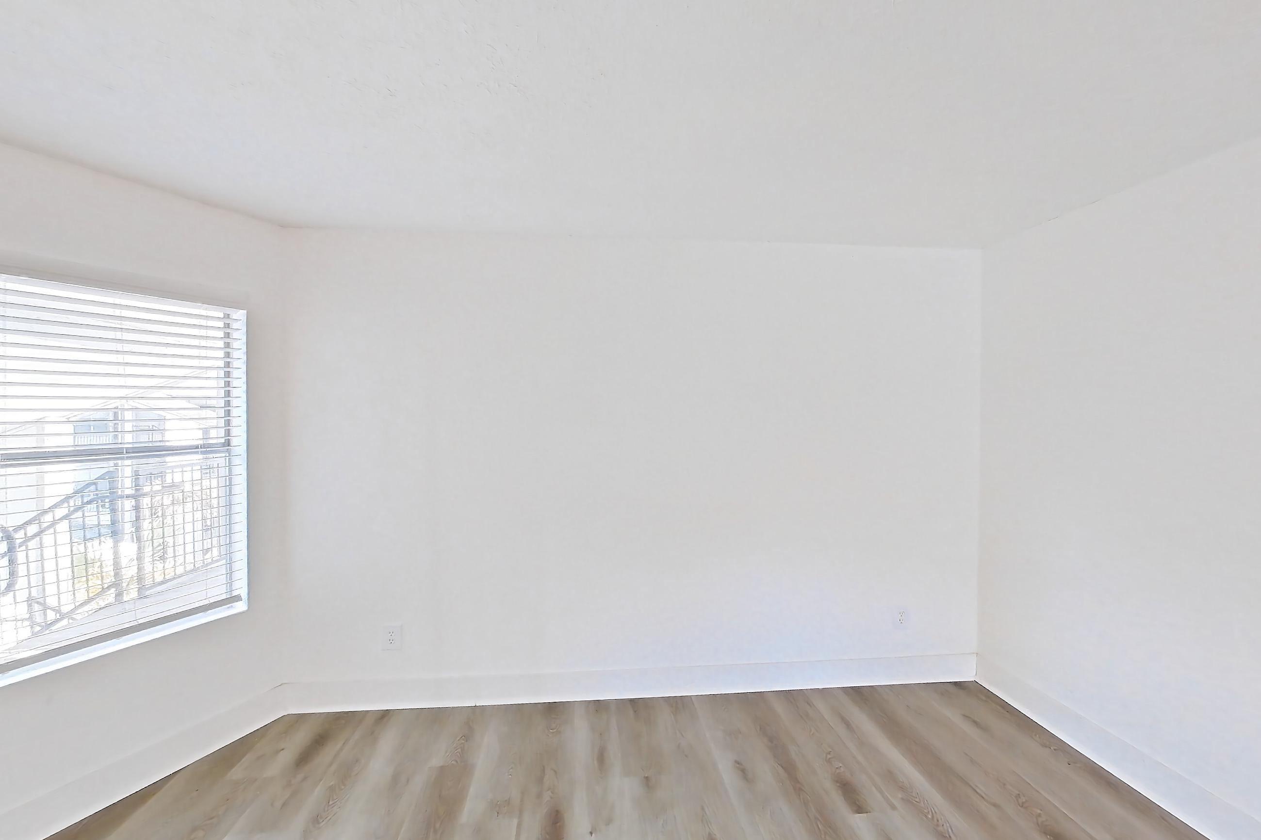 Living room with light wood-finish flooring, refrigerator, and stainless steel appliances, Apartment 20-0517 at Brookwood Club