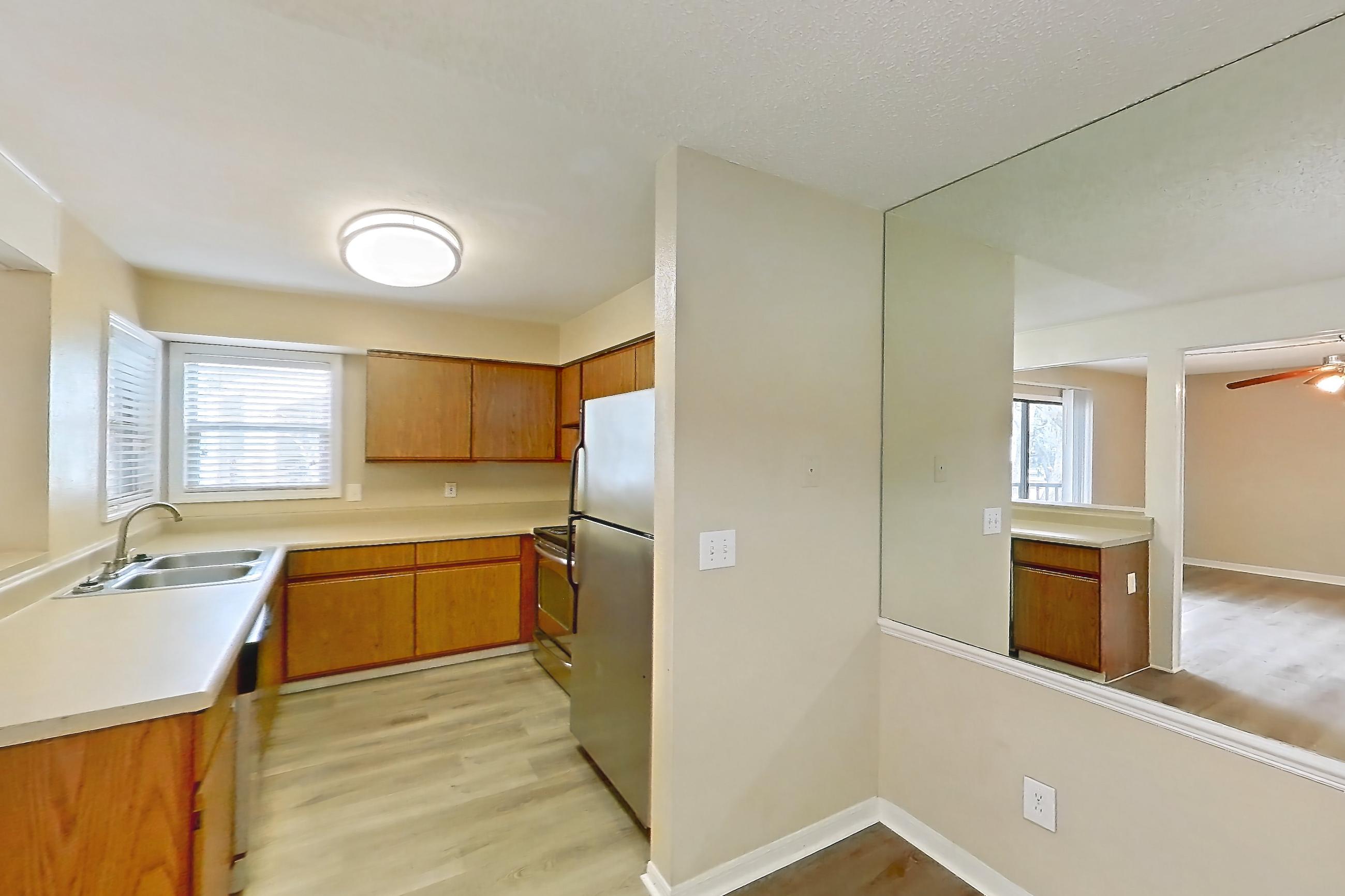 Dining room with light countertops, light wood-finish flooring, oven/range, refrigerator, and stainless steel appliances, Apartment 4038SL at Oak Ramble