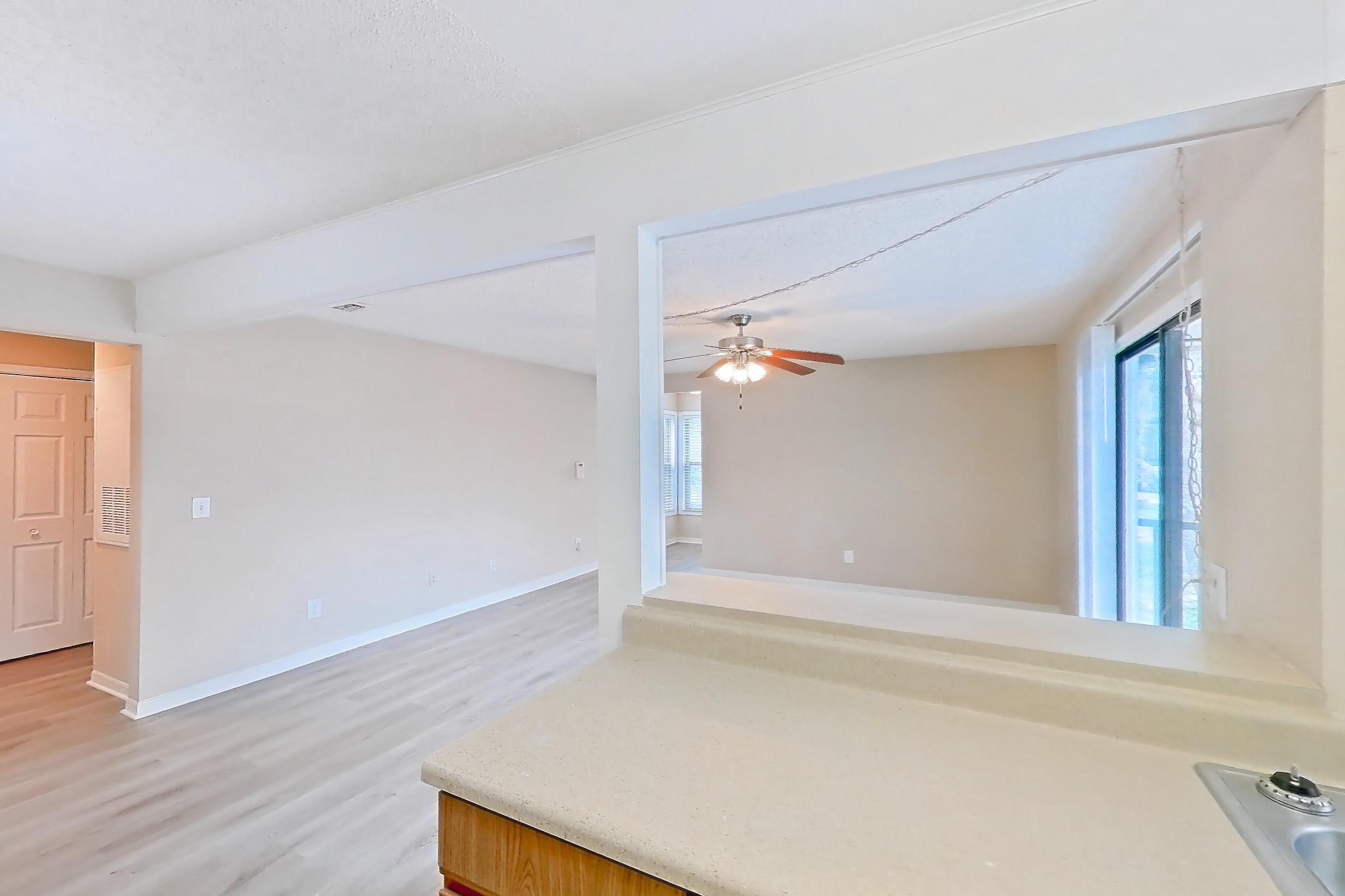 Kitchen with dishwasher, electric range, light countertops, light wood-finish flooring, oven/range, refrigerator, stainless steel appliances, and white appliances, Apartment 4038SL at Oak Ramble