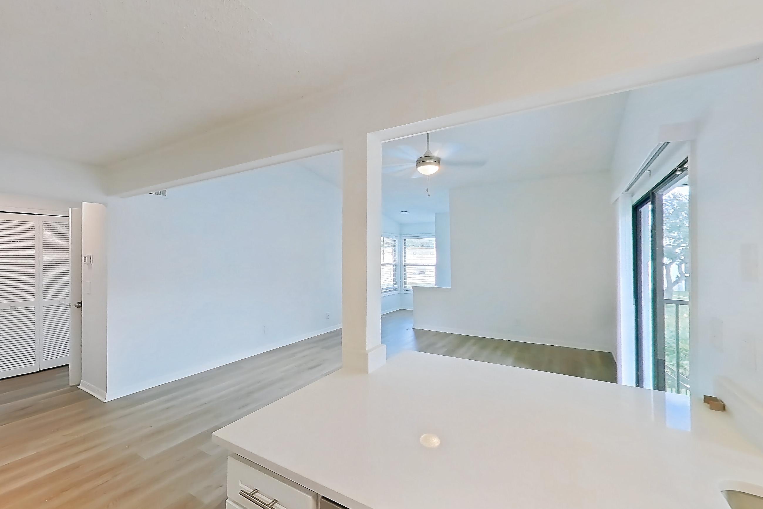 Kitchen with dishwasher, electric range, light countertops, light stone countertops, light wood-finish flooring, microwave, oven/range, refrigerator, and stainless steel appliances, Apartment 6016GD at Oak Ramble