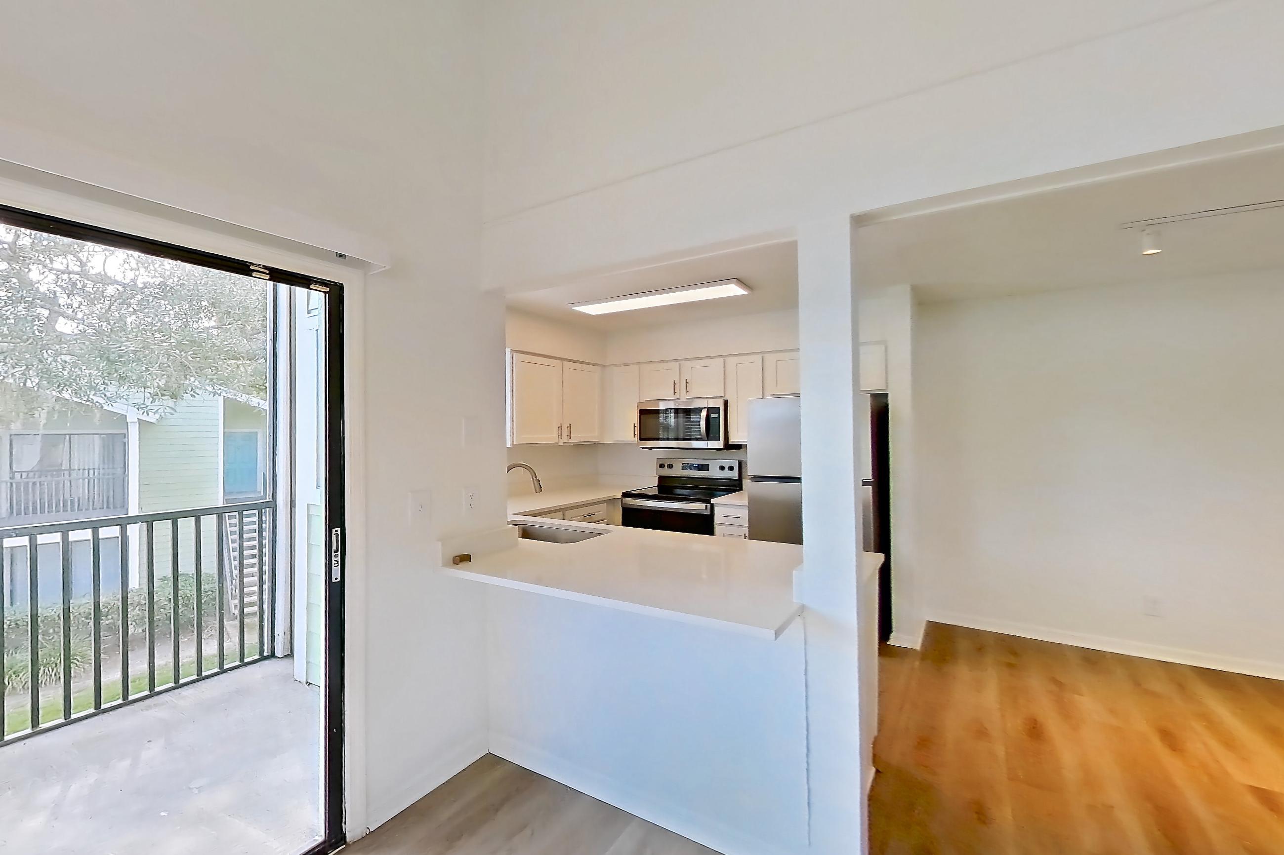 Living space with electric range, light countertops, light wood-finish flooring, oven/range, refrigerator, and stainless steel appliances, Apartment 6016GD at Oak Ramble
