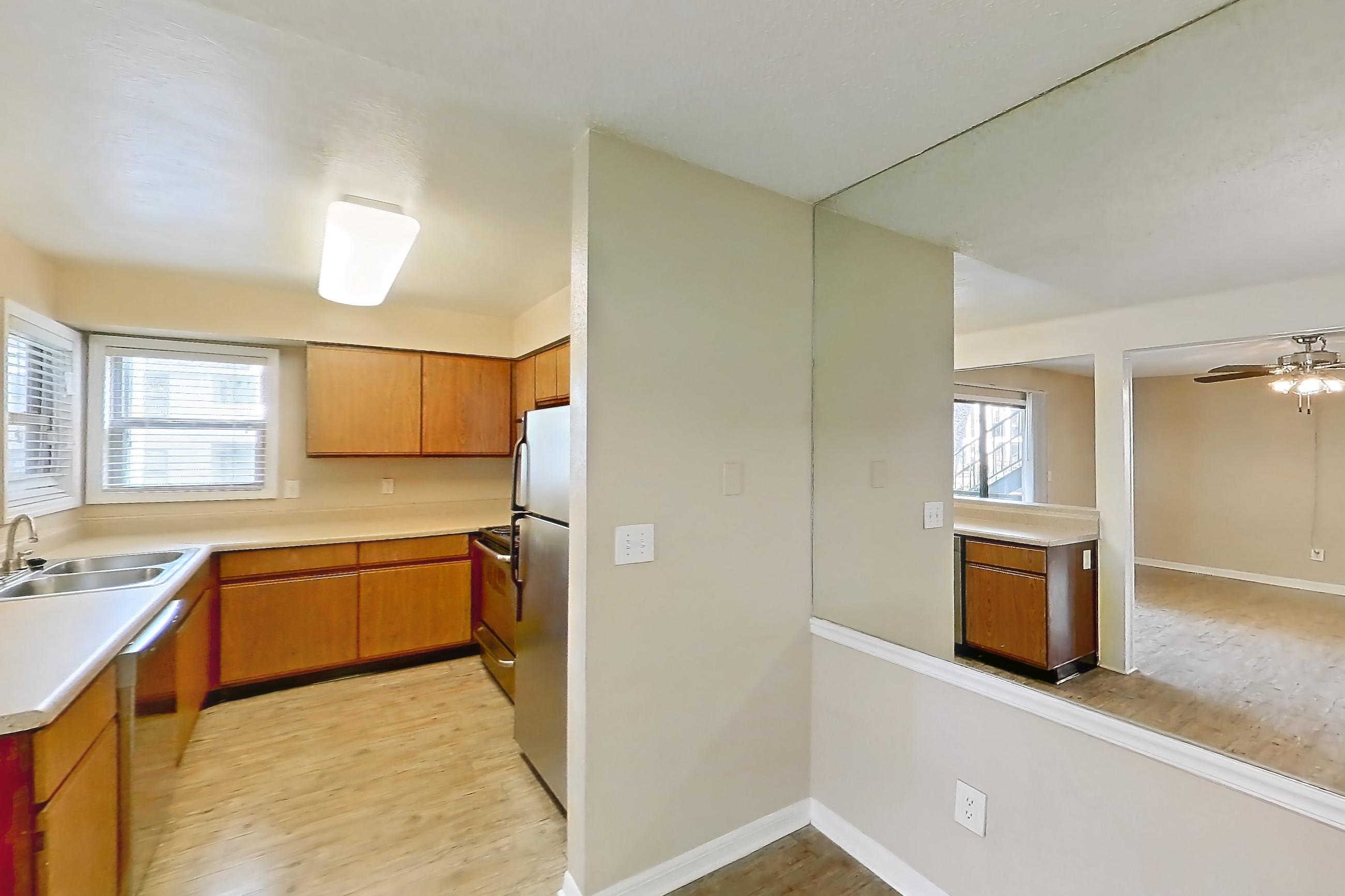 Dining room with dishwasher, light countertops, light wood-finish flooring, oven/range, refrigerator, and stainless steel appliances, Apartment 5021MB at Oak Ramble