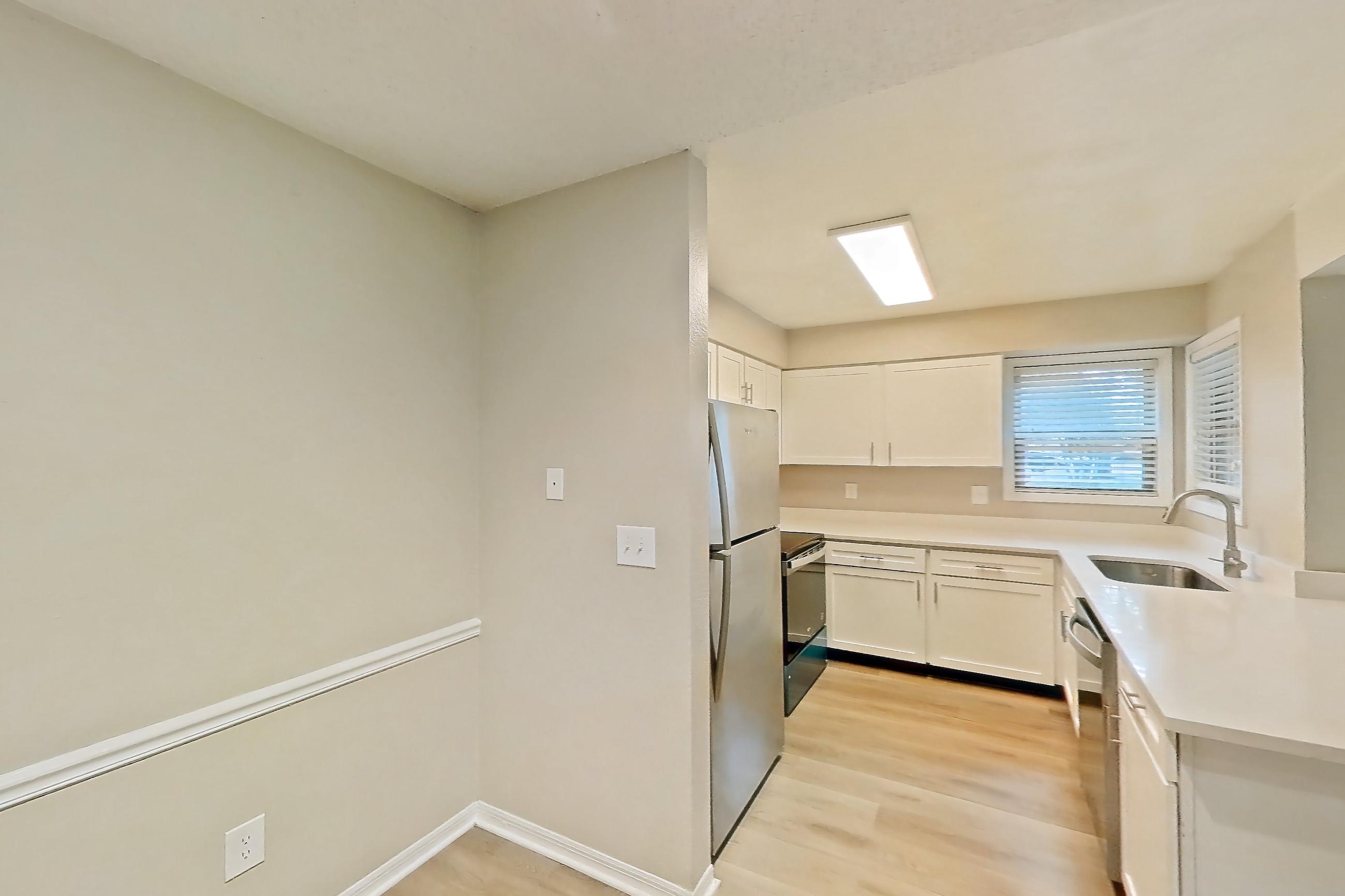 Dining room with dishwasher, electric range, light stone countertops, light wood-finish flooring, oven/range, refrigerator, stainless steel appliances, and white appliances, Apartment 6125GD at Oak Ramble