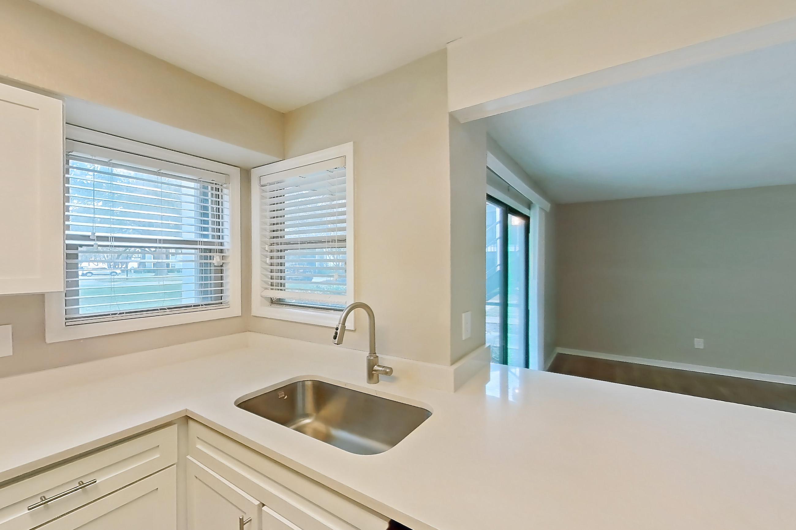Kitchen with dishwasher, electric range, light countertops, light stone countertops, light wood-finish flooring, oven/range, refrigerator, and stainless steel appliances, Apartment 6125GD at Oak Ramble