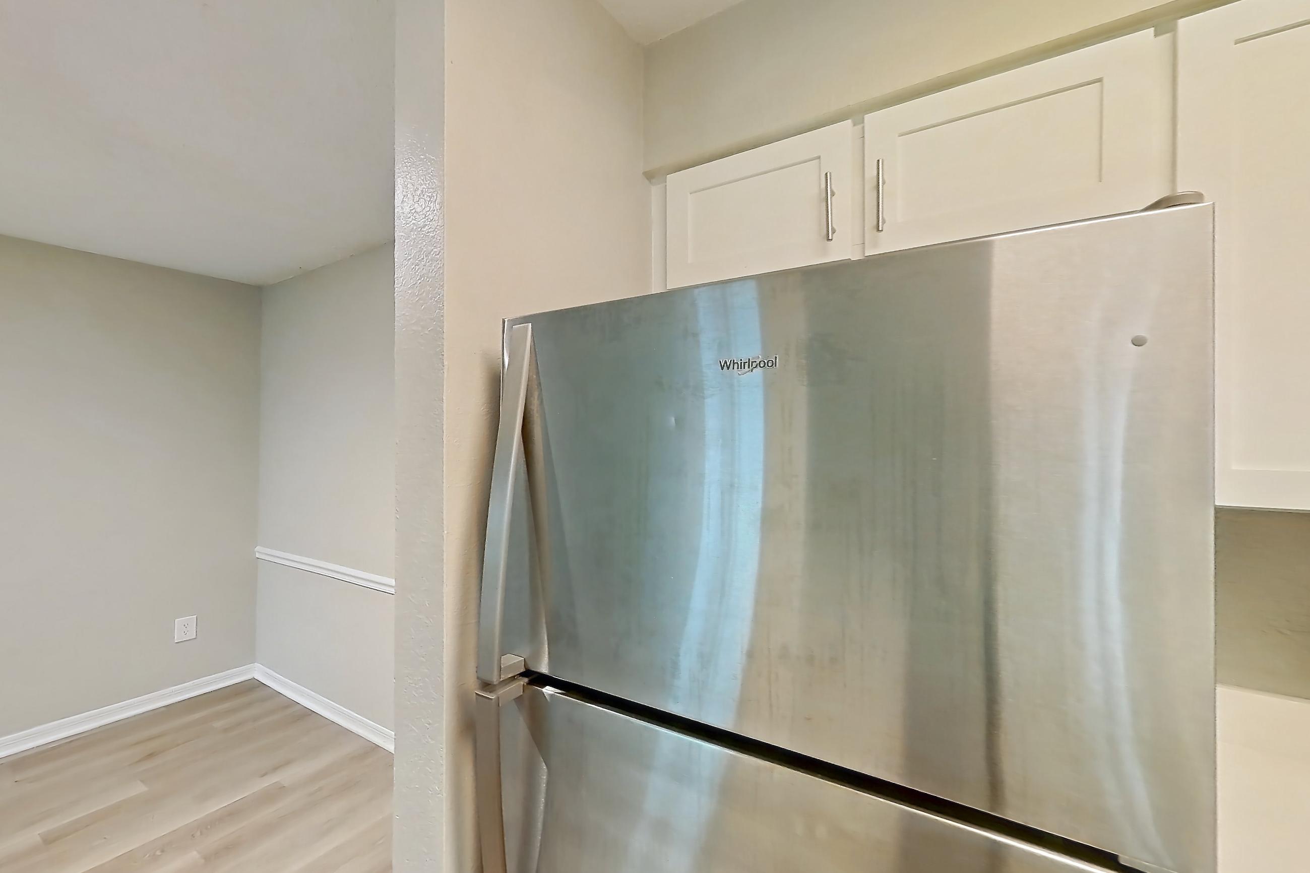 Kitchen with dishwasher, electric range, light countertops, light stone countertops, light wood-finish flooring, oven/range, refrigerator, and stainless steel appliances, Apartment 6125GD at Oak Ramble