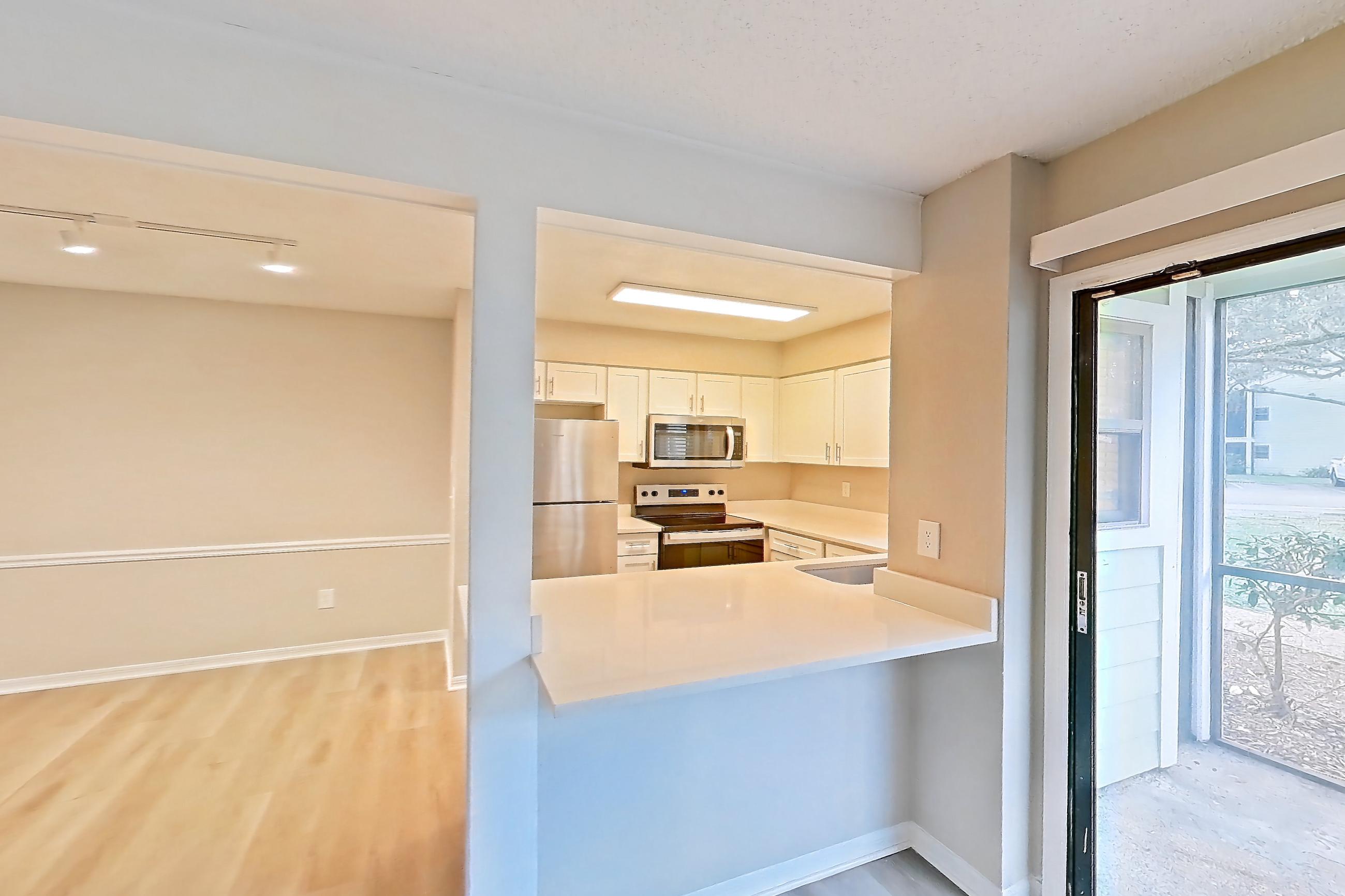 Living space with electric range, light stone countertops, light wood-finish flooring, oven/range, refrigerator, and stainless steel appliances, Apartment 6125GD at Oak Ramble