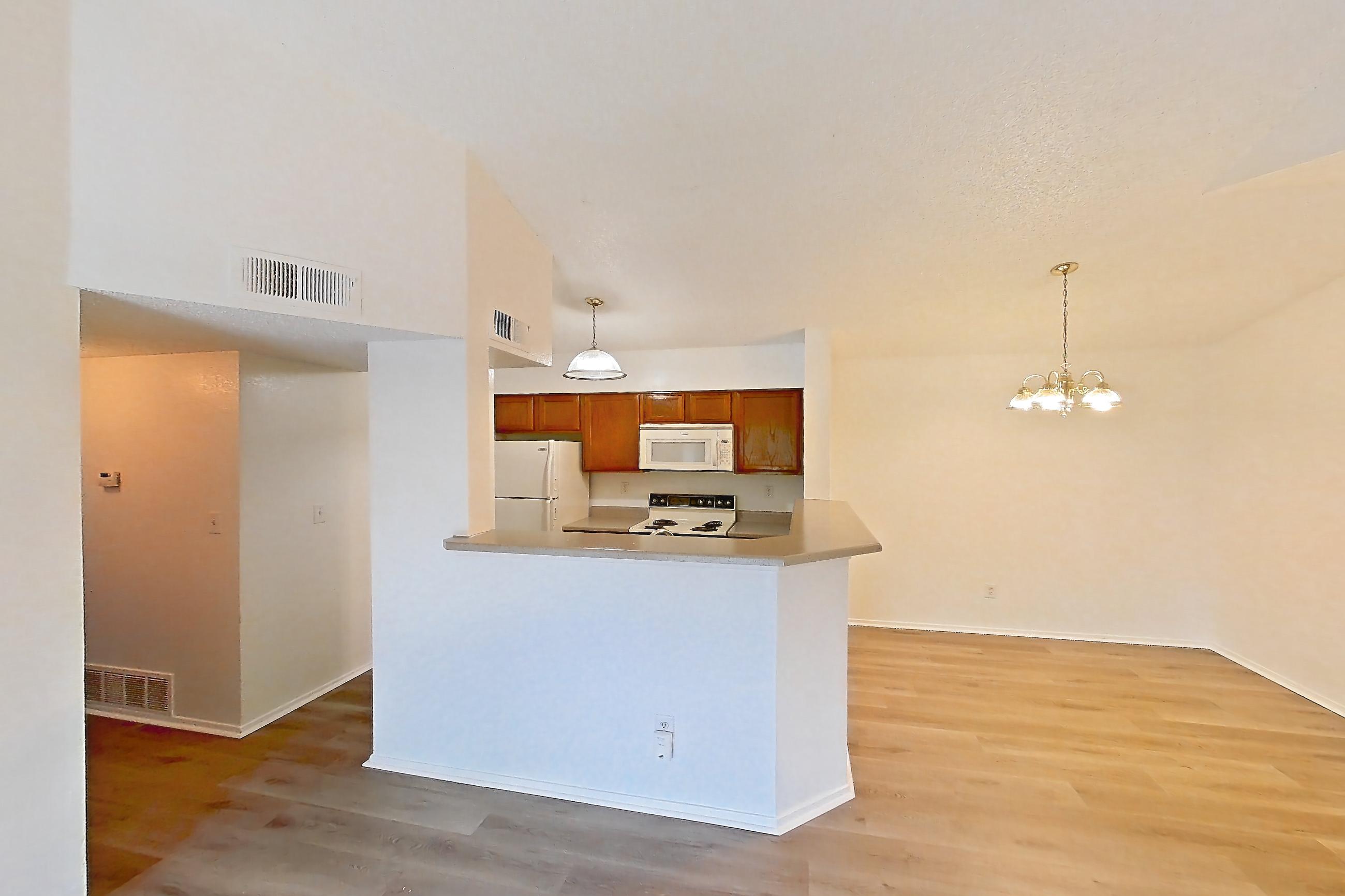 Living space with electric range, light countertops, light wood-finish flooring, oven/range, refrigerator, and white appliances, Apartment 2621 at Canyon Chase