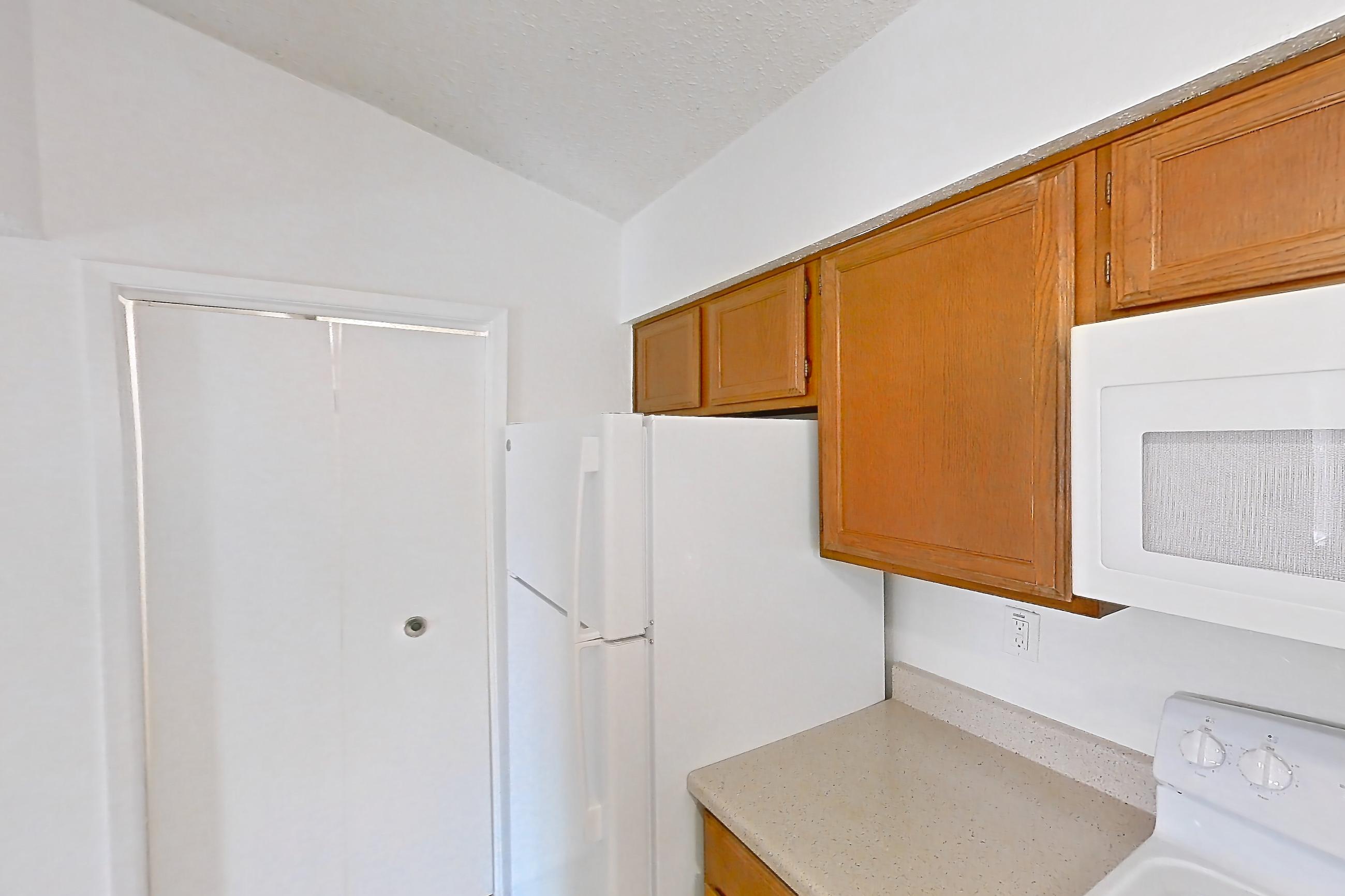 Kitchen with dishwasher, electric range, light stone countertops, light wood-finish flooring, microwave, oven/range, refrigerator, and white appliances, Apartment 4137 at Canyon Chase