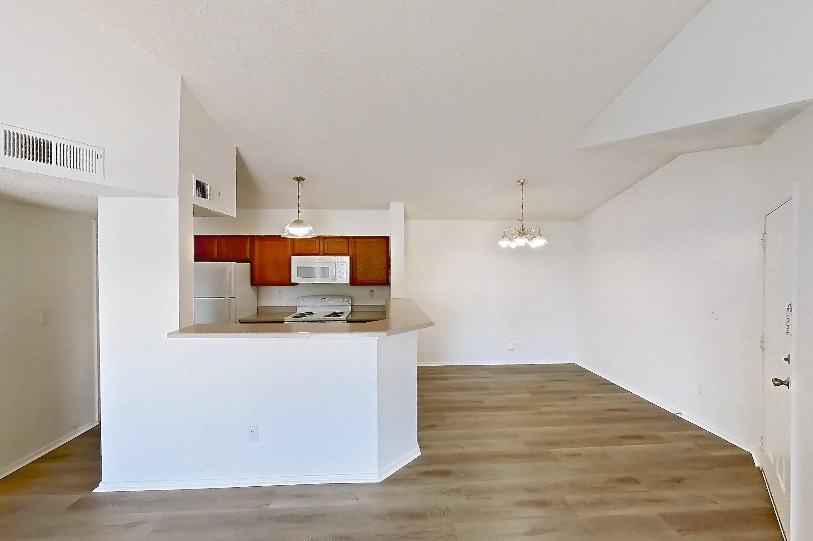Living space with dark wood-finish flooring, electric range, oven/range, refrigerator, and white appliances, Apartment 4137 at Canyon Chase