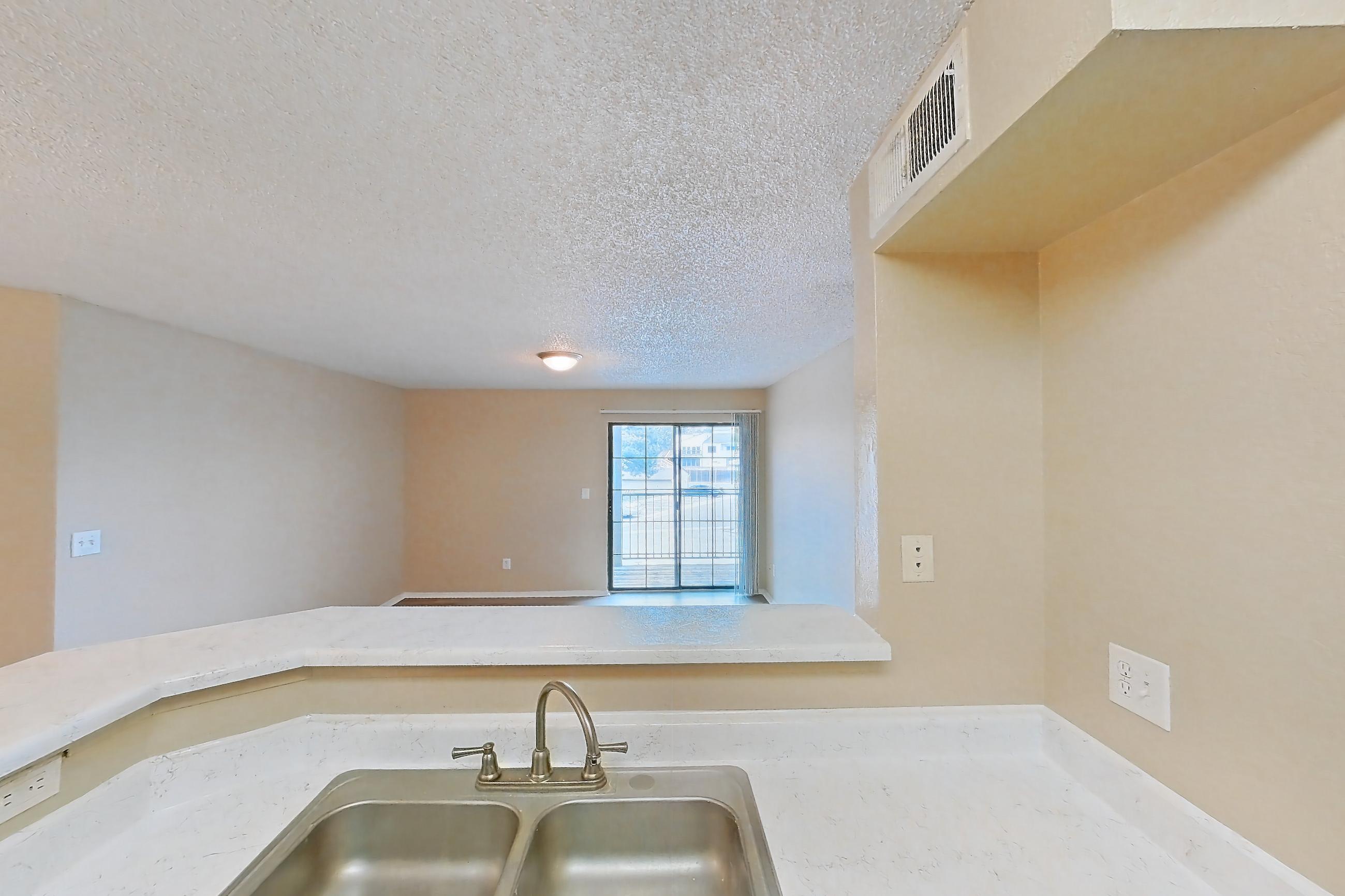 Kitchen with dishwasher, electric range, light countertops, light stone countertops, light wood-finish flooring, microwave, oven/range, refrigerator, and stainless steel appliances, Apartment 3527 at Canyon Chase