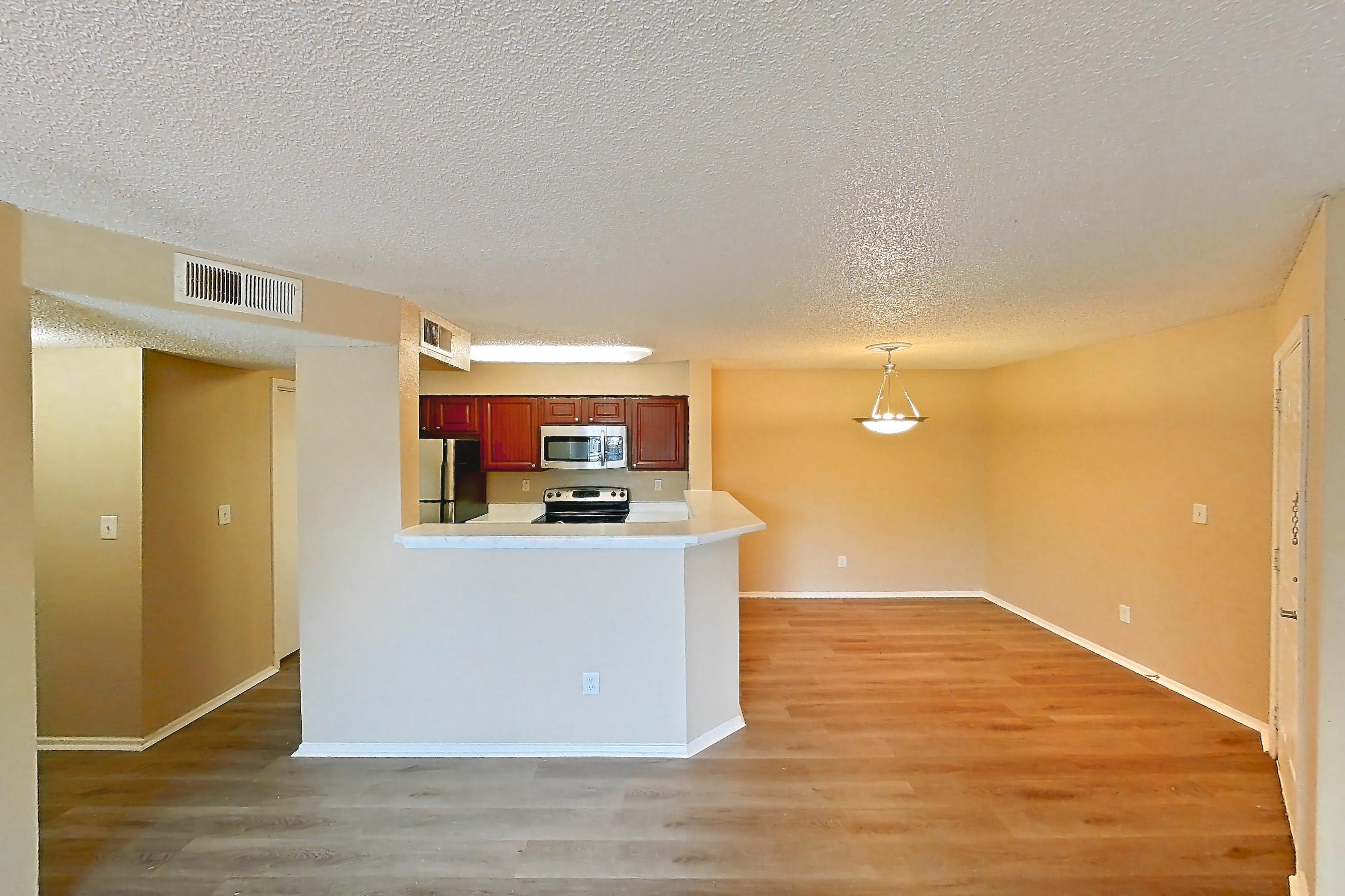 Living space with electric range, light countertops, light wood-finish flooring, oven/range, refrigerator, and stainless steel appliances, Apartment 3527 at Canyon Chase