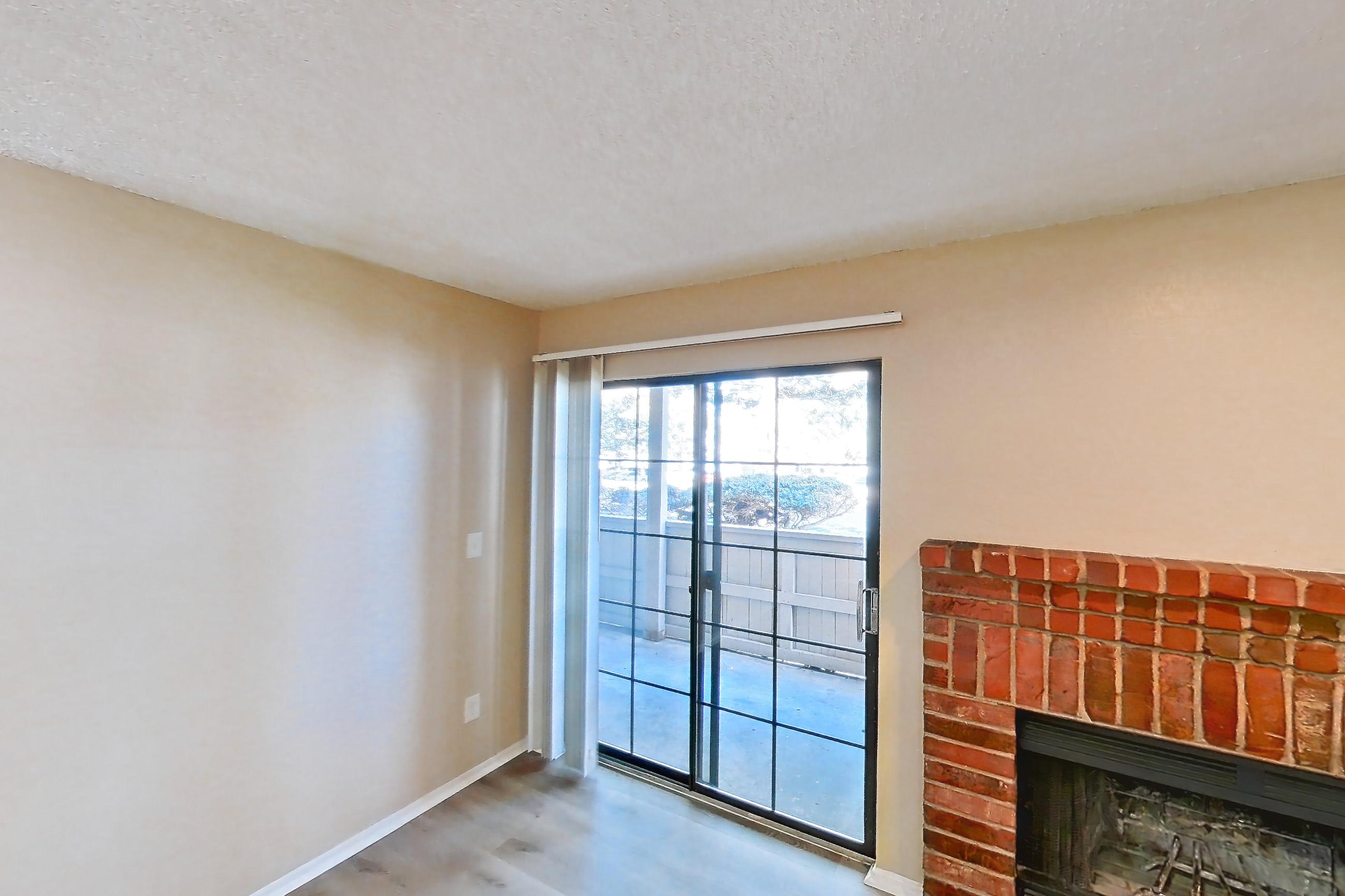 Living space with brick fireplace, electric range, fireplace, light countertops, light wood-finish flooring, oven/range, refrigerator, and stainless steel appliances, Apartment 3514 at Canyon Chase