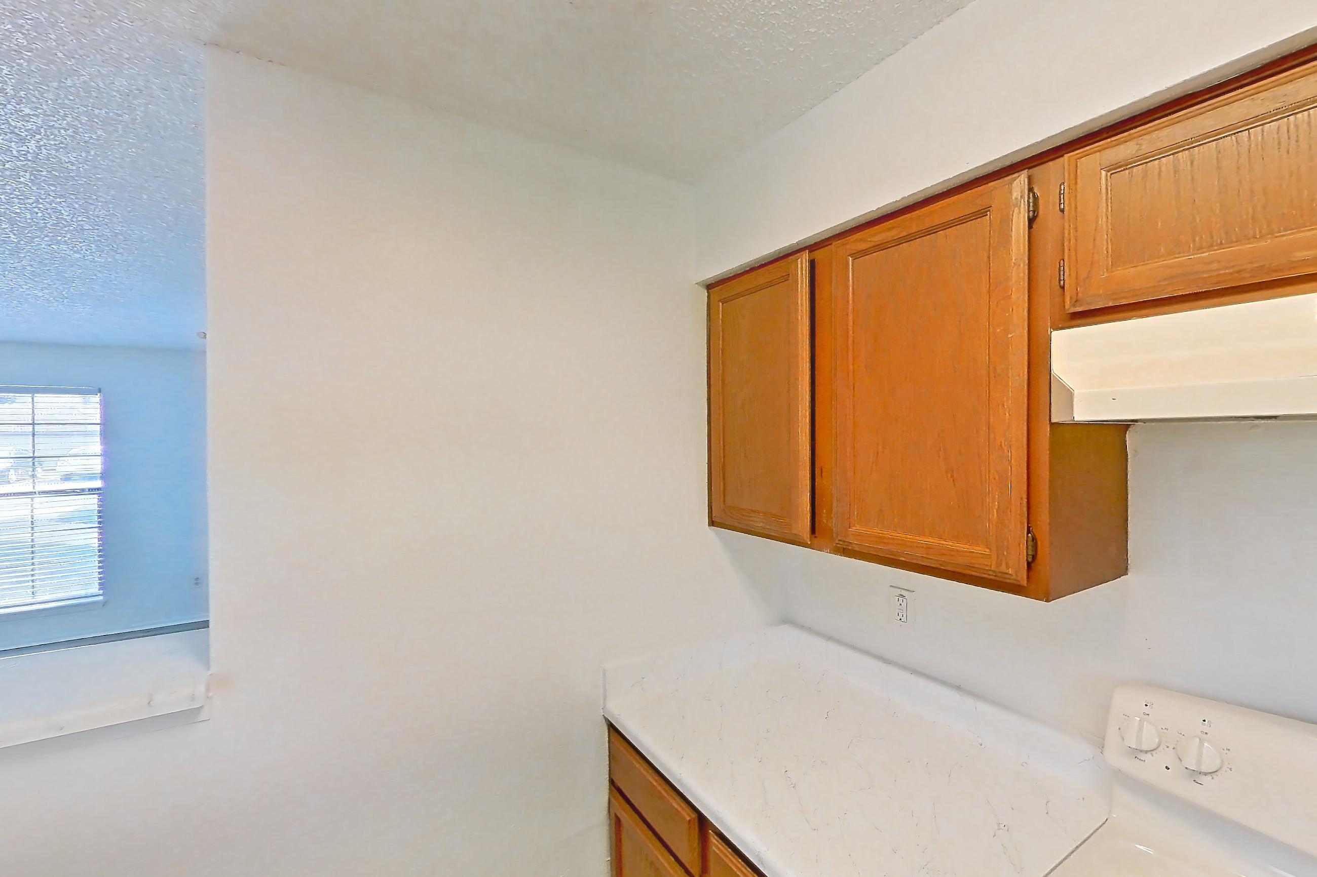 Kitchen with baseboard heating, electric range, light countertops, light stone countertops, light wood-finish flooring, oven/range, refrigerator, and white appliances, Apartment 4214 at Canyon Chase