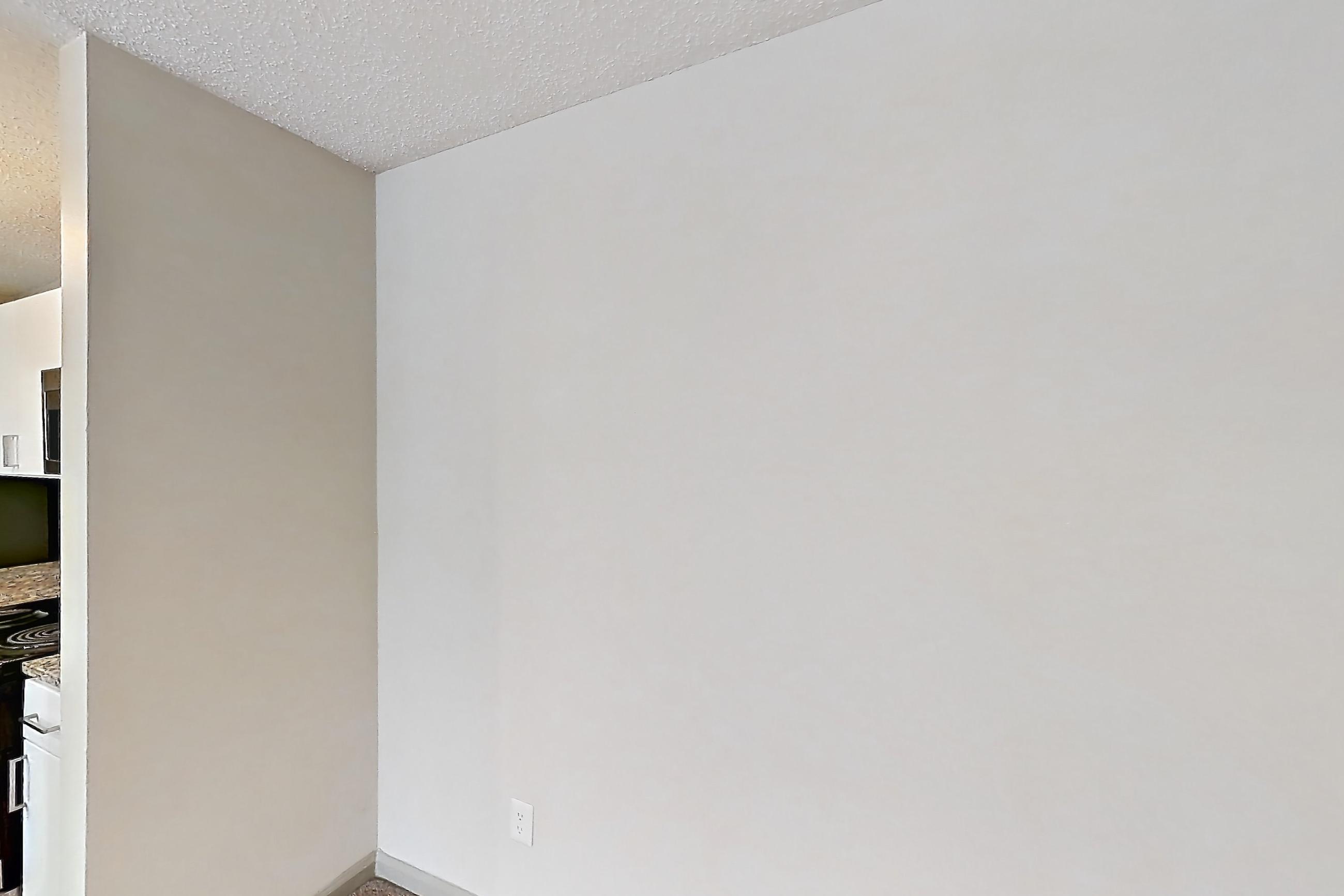 Dining room with dark carpet, electric range, fireplace, light stone countertops, refrigerator, stainless steel appliances, and tile fireplace, Apartment 61-D15 at Crosstown at Chapel Hill