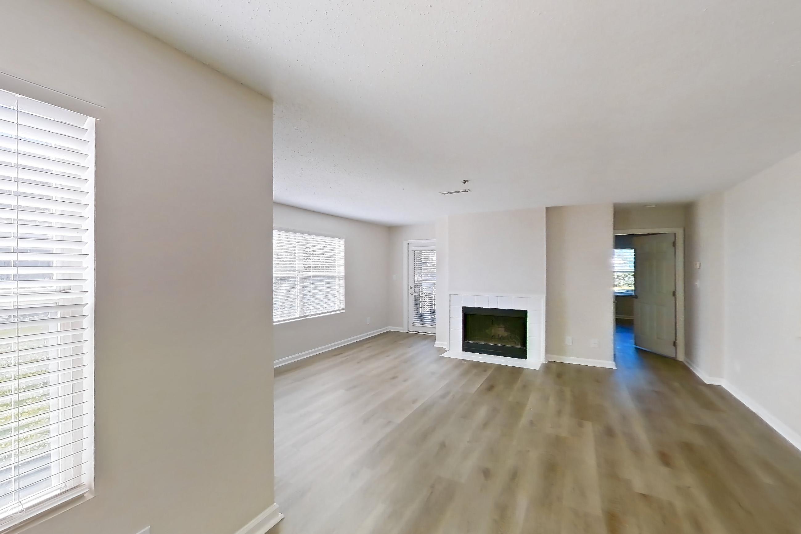 Dining room with fireplace, light wood-finish flooring, and tile fireplace, Apartment 61-E10 at Crosstown at Chapel Hill